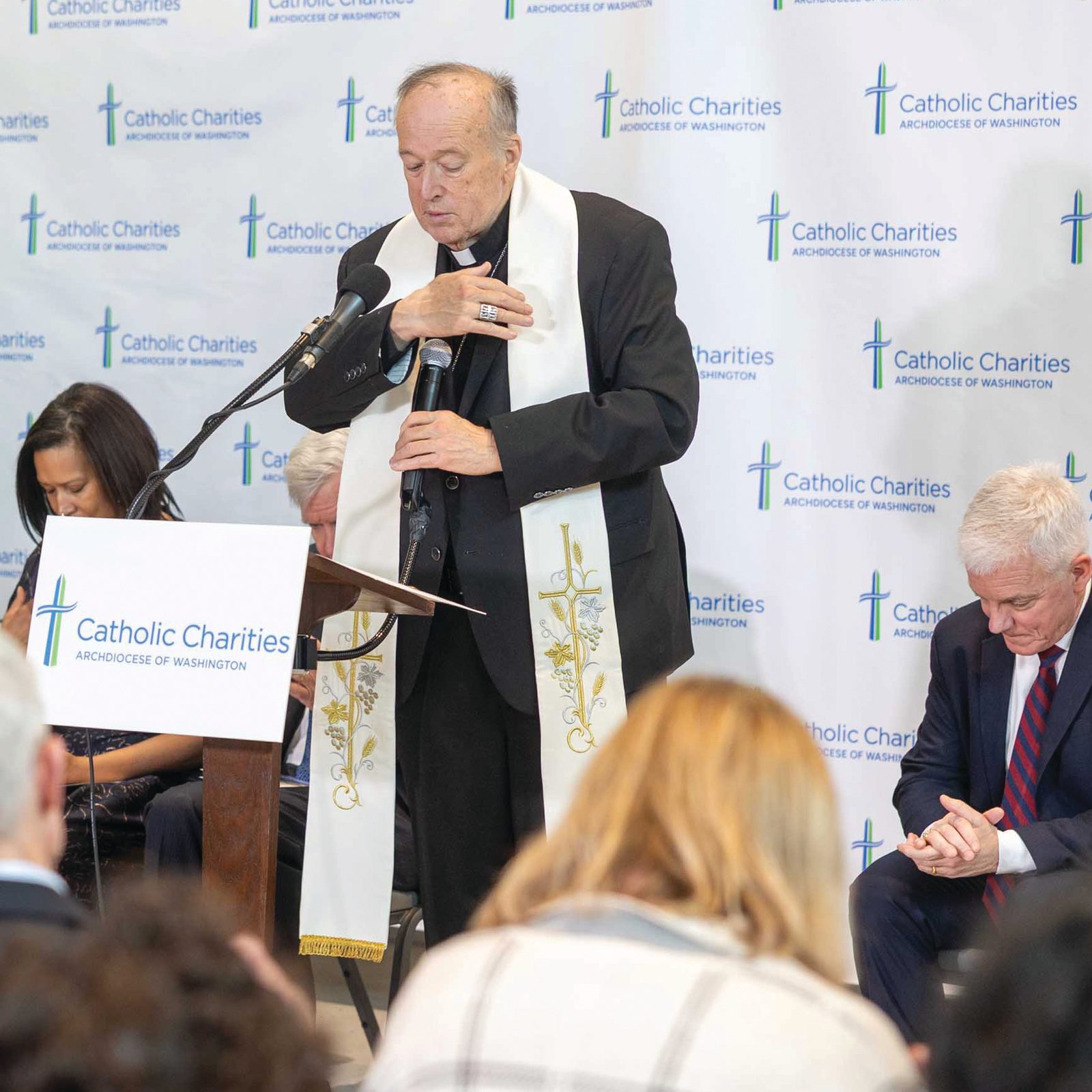 Cardinal Robert W. McElroy offers a prayer Feb. 11 as he blesses the new Conway Education Center that serves children and young adults with developmental differences and houses a child development center. Behind the cardinal are (from left) Adenrele Davis, a mother of a student enrolled at the center and who also works there; Matthew Putu, executive director of developmental disabilities services at Catholic Charities D.C.; Washington Mayor Muriel Bowswer; William E. Conway Jr., a co-founder of The Carlyle Group whose Bedford Falls Foundation made a substantial donation to fund the new facility; and Jim Malloy, president and CEO of Catholic Charities. (Catholic Standard photo by Mihoko Owada)