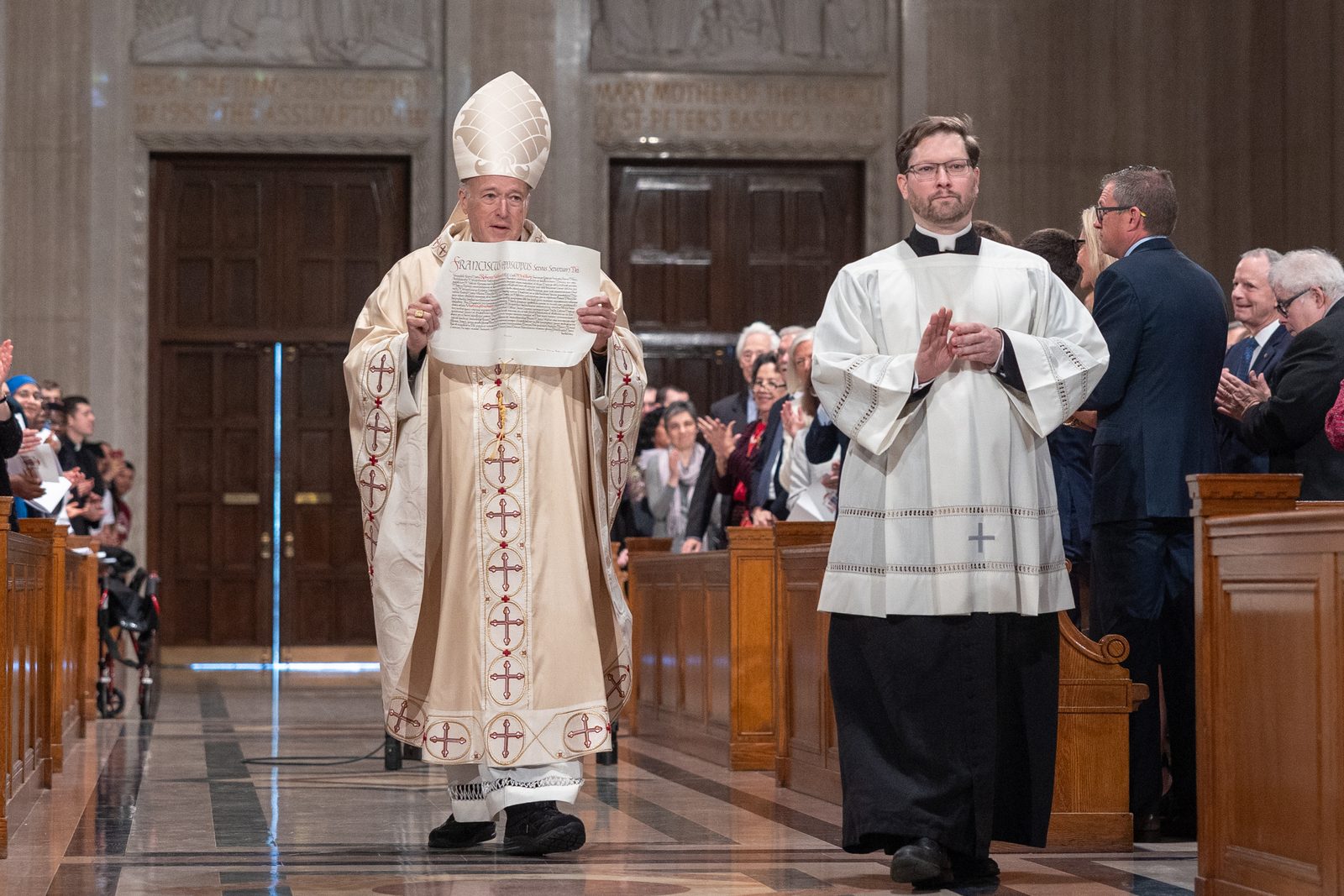Cardinal Robert McElroy holds the apostolic mandate from Pope Francis appointing him as the new archbishop of Washington and displays it for the congregation during his Solemn Mass of Installation on March 11, 2025 at the Basilica of the National Shrine of the Immaculate Conception. (Catholic Standard photo by Mihoko Owada)