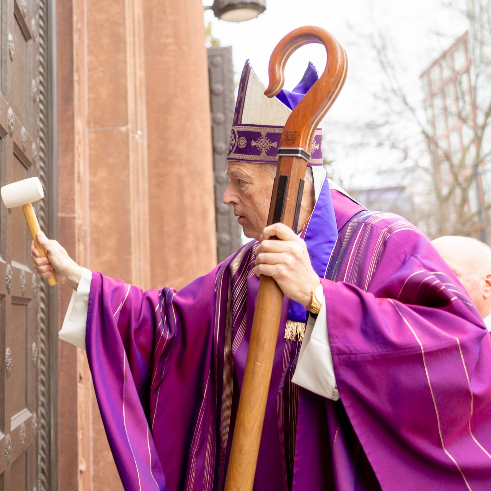 Cardinal Robert W. McElroy knocks on the door of the Cathedral of St. Matthew the Apostle before a March 16, 2025 Mass there, symbolizing his arrival to take possession of his cathedral church and to be welcomed there as the new archbishop of Washington. Cardinal McElroy was installed as the archbishop of Washington five days earlier at a Mass at the Basilica of the National Shrine of the Immaculate Conception. (Catholic Standard photo by Mihoko Owada)