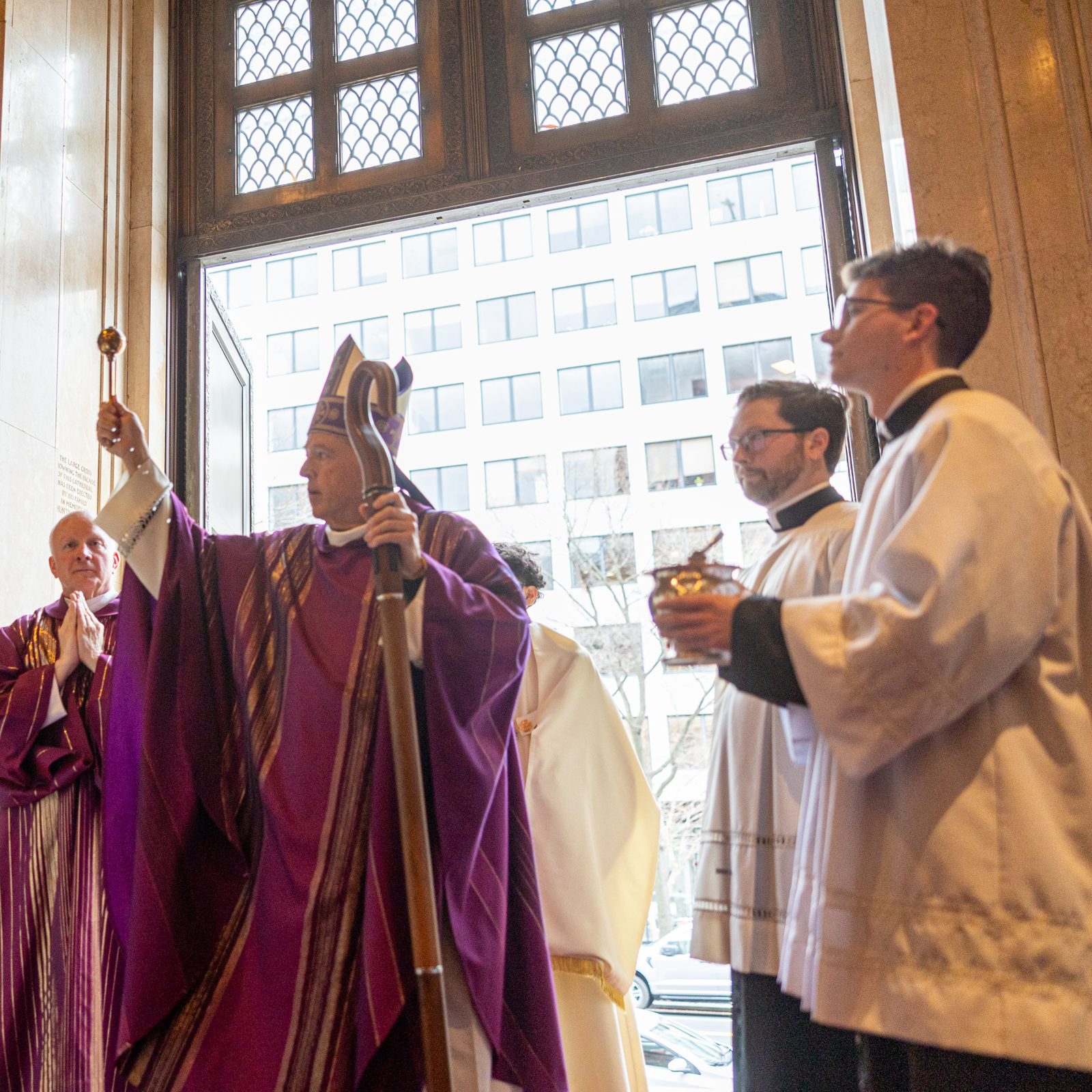 Cardinal Robert W. McElroy, the new archbishop of Washington, sprinkles holy water inside the Cathedral of St. Matthew the Apostle after arriving to celebrate a Mass there on March 16, 2025. At left is Msgr. W. Ronald Jameson, the cathedral’s rector. (Catholic Standard photo by Mihoko Owada)