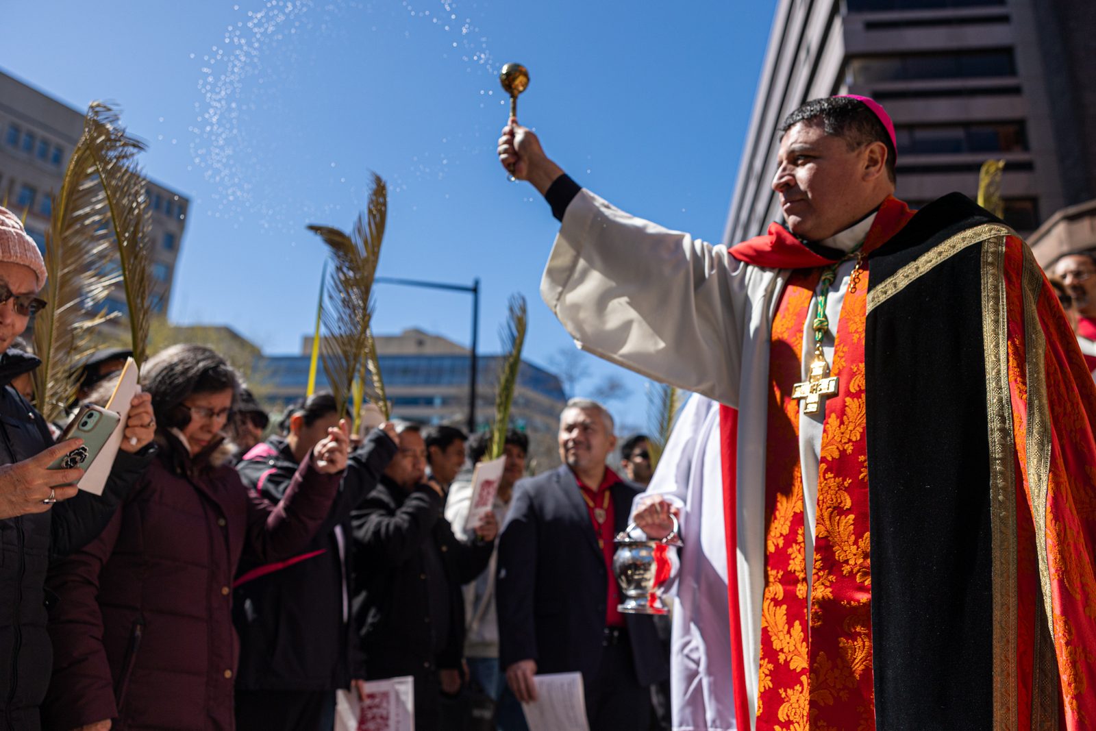 Auxiliary Bishop Evelio Menjivar blesses palms as people gather outside the Cathedral of St. Matthew the Apostle in Washington, D.C., for the beginning of the Palm Sunday of the Lord’s Passion Mass on March 24, 2024 that marked the start of Holy Week. (Catholic Standard photo by Mihoko Owada)