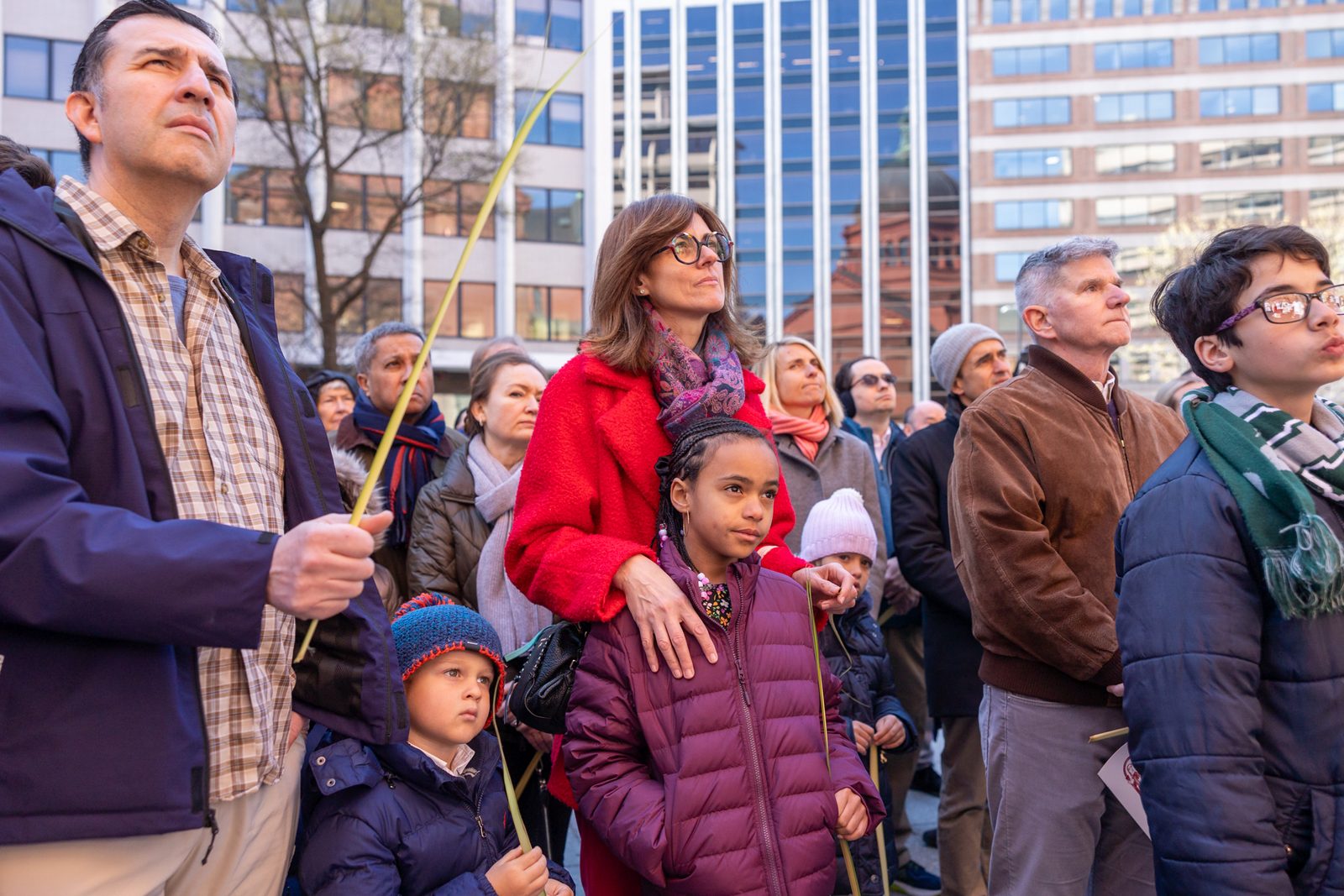 People stand outside the Cathedral of St. Matthew the Apostle in Washington, D.C., holding palms at the beginning of the Palm Sunday of the Lord’s Passion Mass on March 24, 2024 celebrated by Cardinal Wilton Gregory. (Catholic Standard photo by Mihoko Owada)