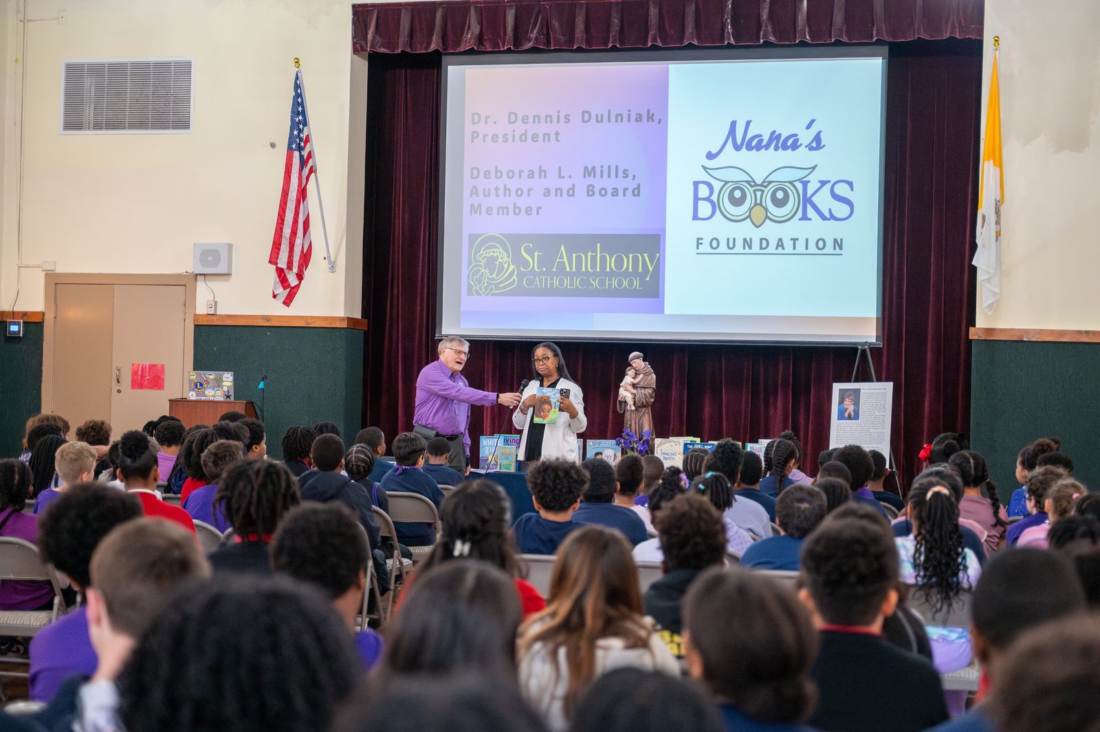 During an April 7 assembly at St. Anthony Catholic School in Washington, Dr. Dennis Dulniak, president of Nana’s Books Foundation, and author and board member Deborah L. Mills shared personal stories about loved ones who were diagnosed with dementia. Dr. Dulniak distributed 613 grade-appropriate books on Alzheimer’s, dementia, and disabilities on behalf of the foundation, Nana's Books, to the school’s 221 students in memory of Dulniak’s late wife, Nancy, a lifelong librarian who died from early onset Alzheimer’s in 2021. (Catholic Standard Photo by Nicole Olea)