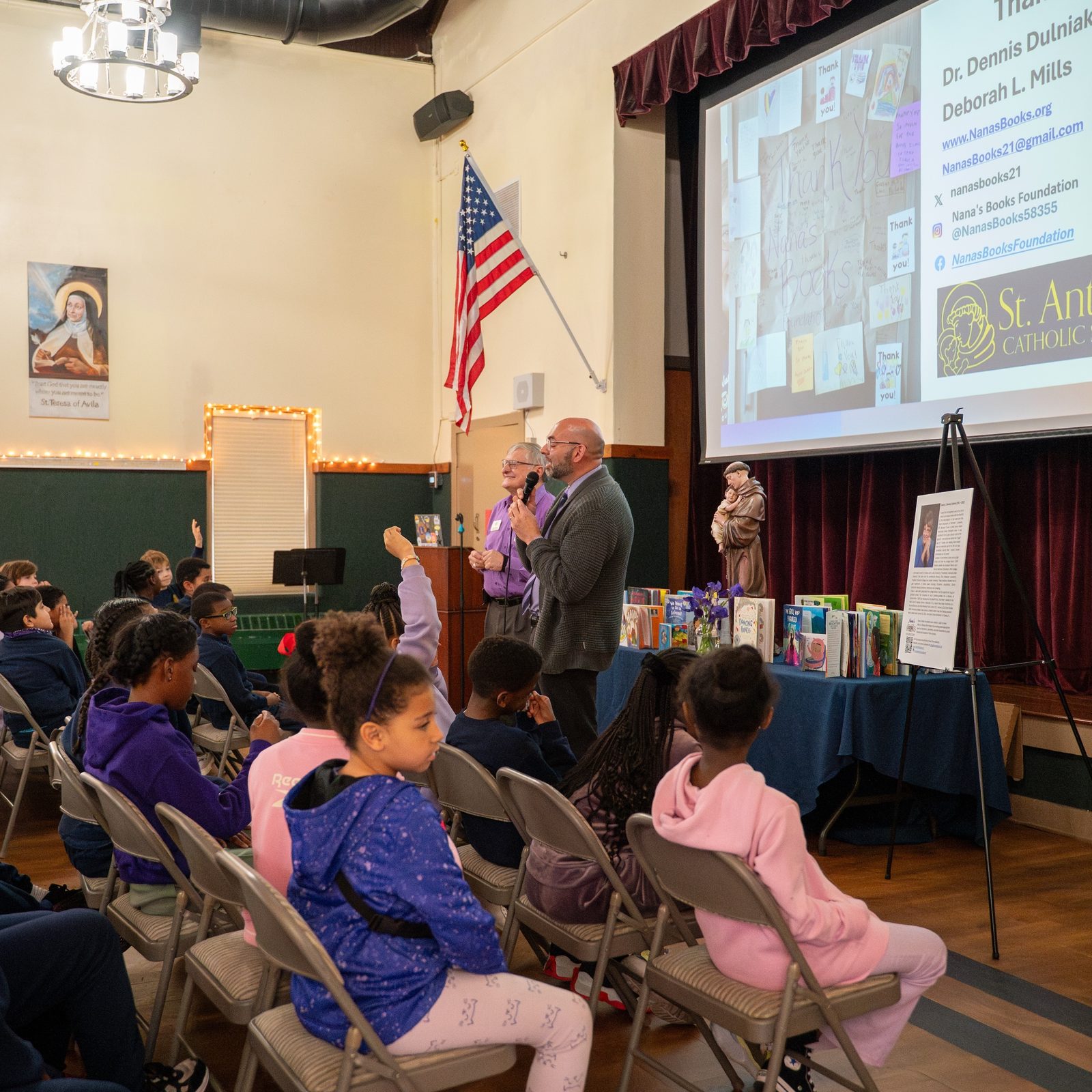 Dr. Dennis Dulniak, president of Nana’s Books Foundation, and Michael Thomasian, the principal of St. Anthony Catholic School in Washington, respond to students’ questions during an assembly at the school on April 7. Students asked about Alzheimer’s disease, memory loss, and the inspiration behind the foundation’s book donation. (Catholic Standard photo by Nicole Olea)