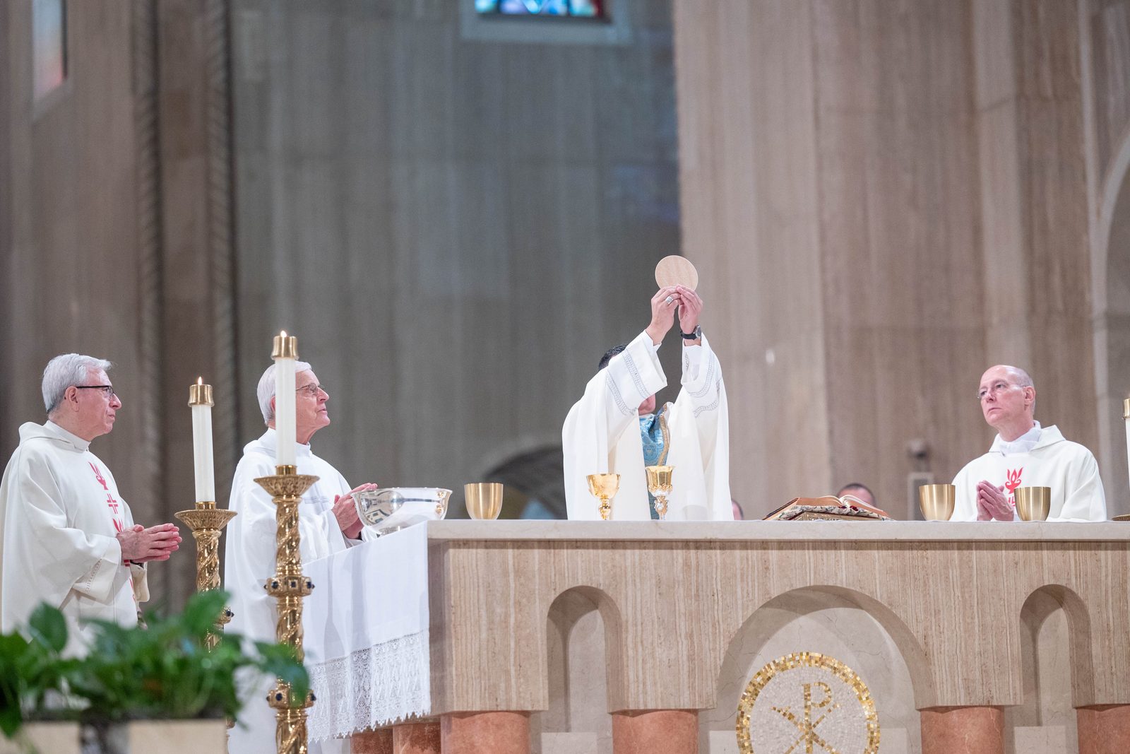 During the June 8 Mass at the Basilica of the National Shrine of the Immaculate Conception that preceded a Eucharistic procession through the Brookland neighborhood of Washington, D.C., Washington Auxiliary Bishop Evelio Menjivar elevates the Eucharist during the consecration. At left is Cardinal Donald Wuerl, the archbishop emeritus of Washington, and at right is Msgr. Walter Rossi, rector of the National Shrine. (CS photo by Mihoko Owada)