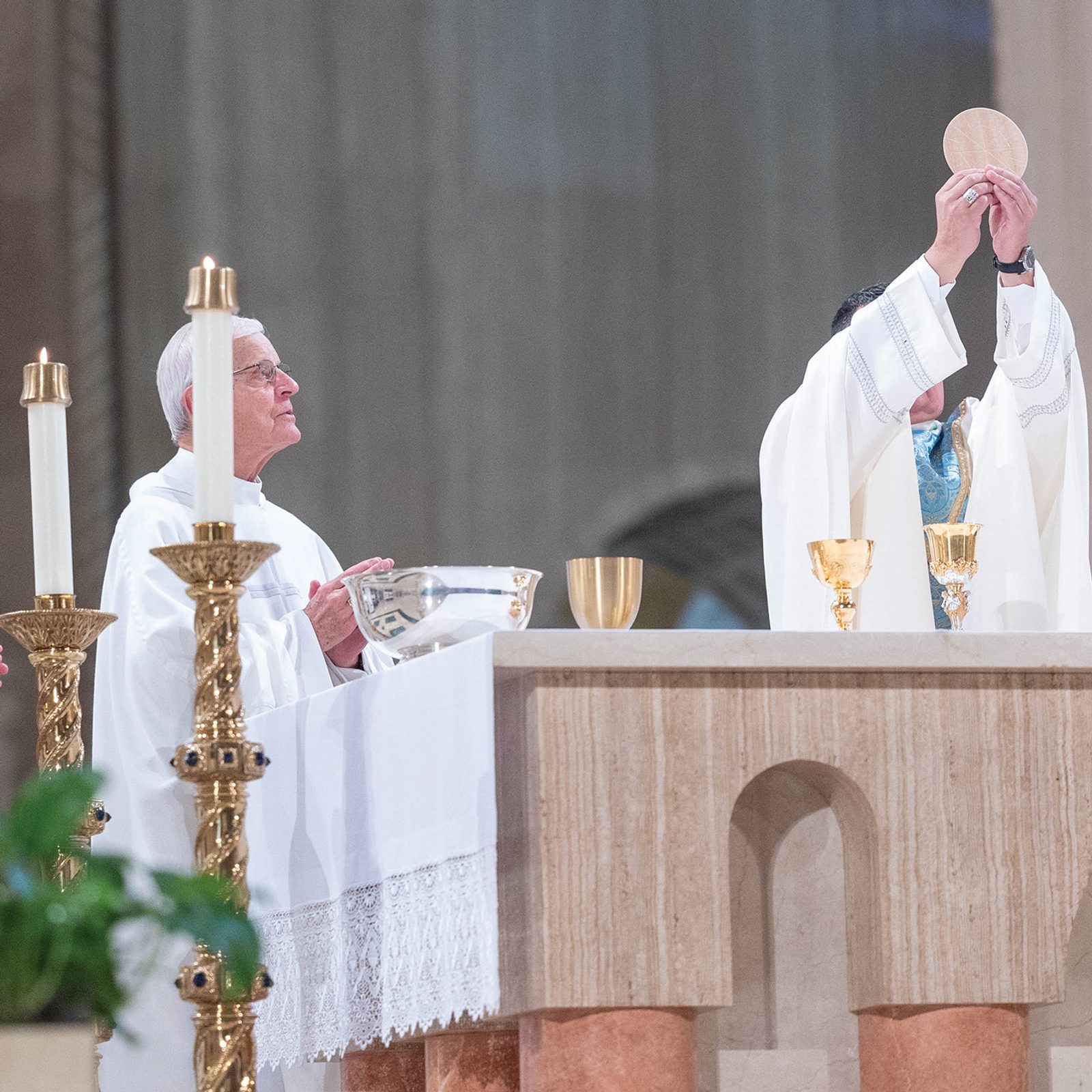 During the  June 8 Mass at the Basilica of the National Shrine of the Immaculate Conception that preceded a Eucharistic procession through the Brookland neighborhood of Washington, D.C., Washington Auxiliary Bishop Menjivar elevates the Eucharist during the consecration. At left is Cardinal Donald Wuerl, the archbishop emeritus of Washington, and at right is Msgr. Walter Rossi, rector of the National Shrine. (CS photo by Mihoko Owada)