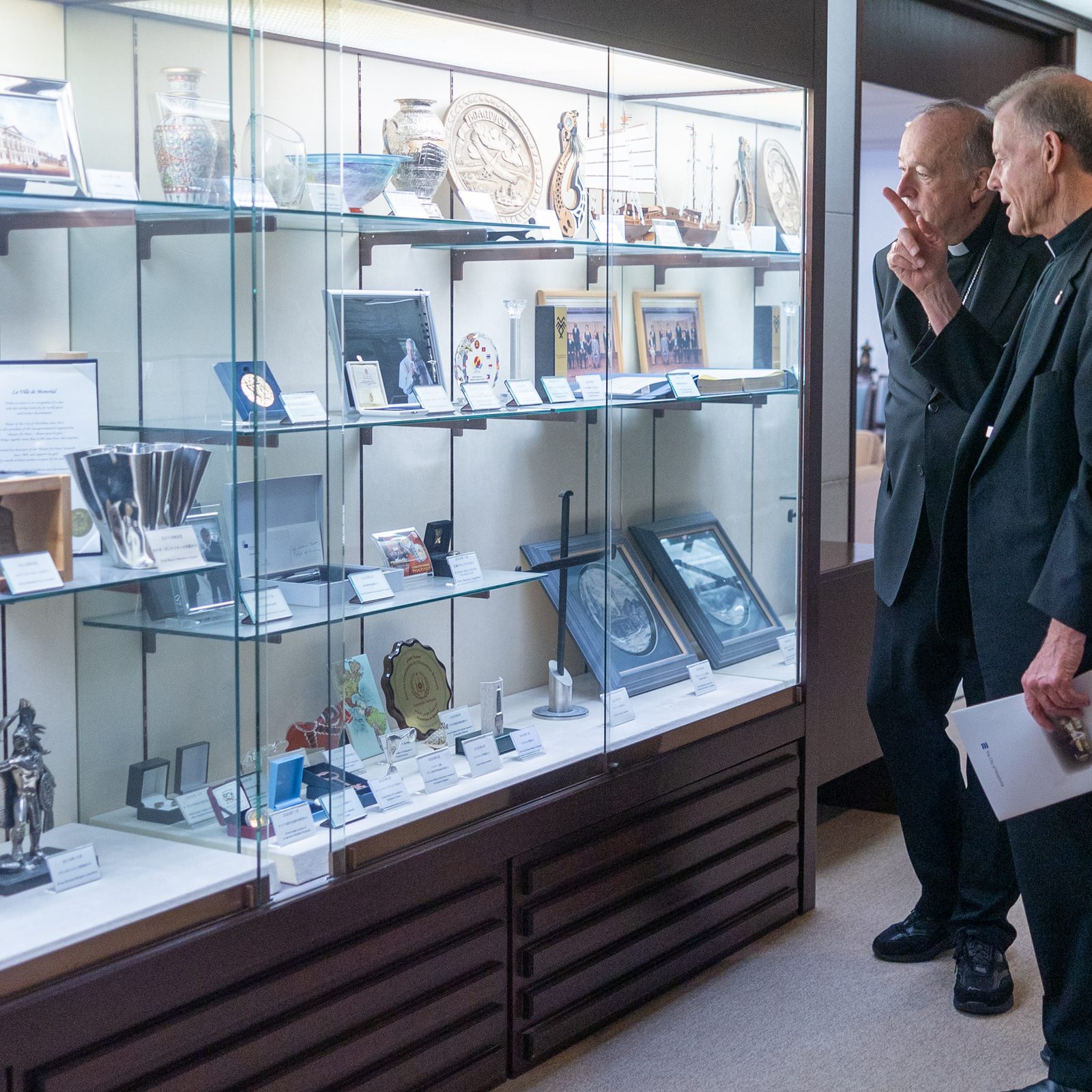 Cardinal Robert W. McElroy of Washington and Archbishop John C. Wester of Santa Fe, New Mexico, look at a display of photos and messages from Pope Francis' visit to Hiroshima in 2019. ( Catholic Standard photo by Mihoko Owada)