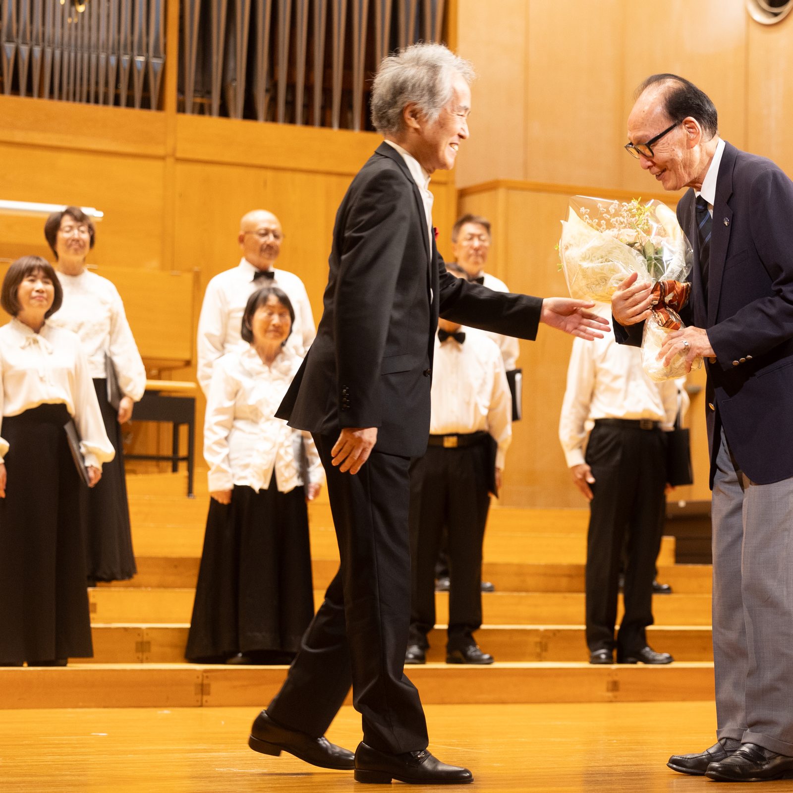 At right, Hiroshi Kanamoto – who was nine months old when the United States dropped an atomic bomb on Hiroshima on Aug. 6, 1945 – receives flowers at a peace event hosted on Aug. 5, 2025 by the Diocese of Hiroshima that was part of a Pilgrimage of Peace to Japan by U.S. archbishops and by students and leaders from U.S. Catholic universities coinciding with the 80th anniversary of the atomic bombings of Hiroshima and Nagasaki. Kanamoto is a member of Nihon Hidankyo, the group of Japanese atomic bomb survivors that received the Nobel Peace Prize in 2024. (Catholic Standard photo by Mihoko Owada)