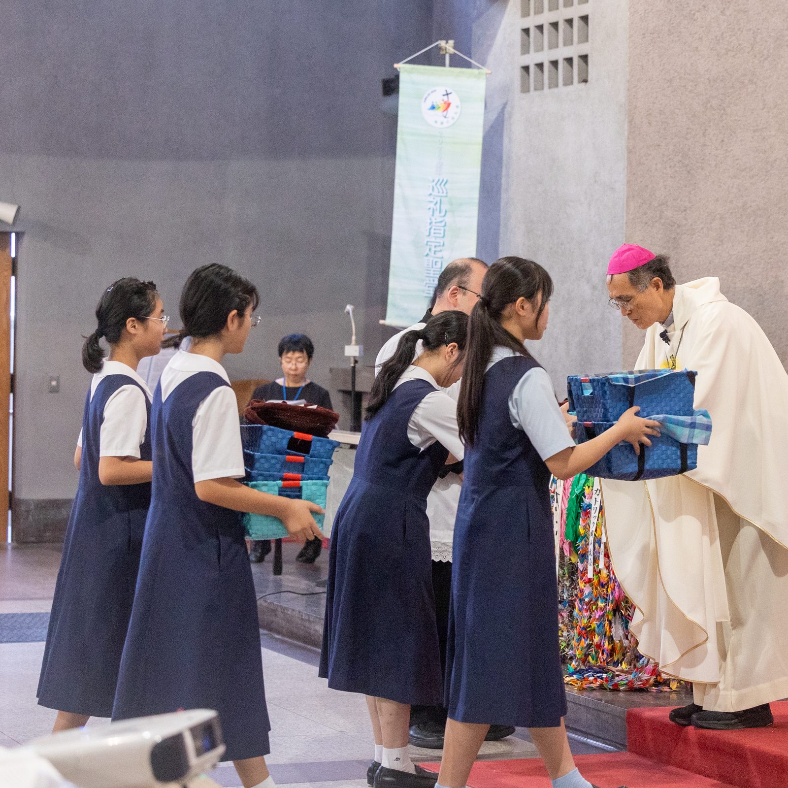Hiroshima Bishop Alexis Mitsuru Shirahama receives offertory gifts from students at a Mass on Aug. 6, 2025 at the World Peace Memorial Cathedral in Hiroshima, Japan, for the Victims of the Atomic Bombing. The Mass was part of a Pilgrimage of Peace of four U.S. archbishops and of U.S. Catholic university leaders and students to Hiroshima and Nagasaki to pray and dialogue for peace on the 80th anniversary of when the atomic bombs were dropped on those cities on Aug. 6 and 9, 1945. (Catholic Standard photo by Mihoko Owada)