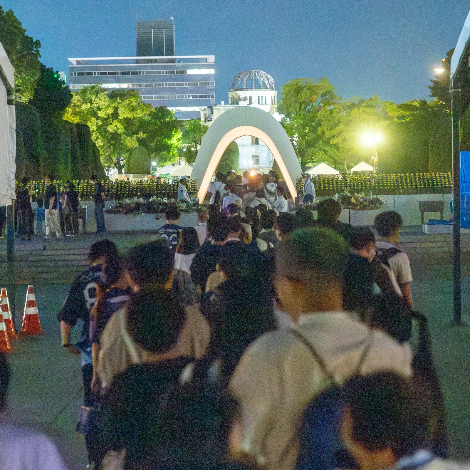 On the evening of Aug. 6, 2025, people line up in front of the Cenotaph for the A-bomb Victims at Hiroshima Peace Park to offer prayers. (Catholic Standard photo by Mihoko Owada)
