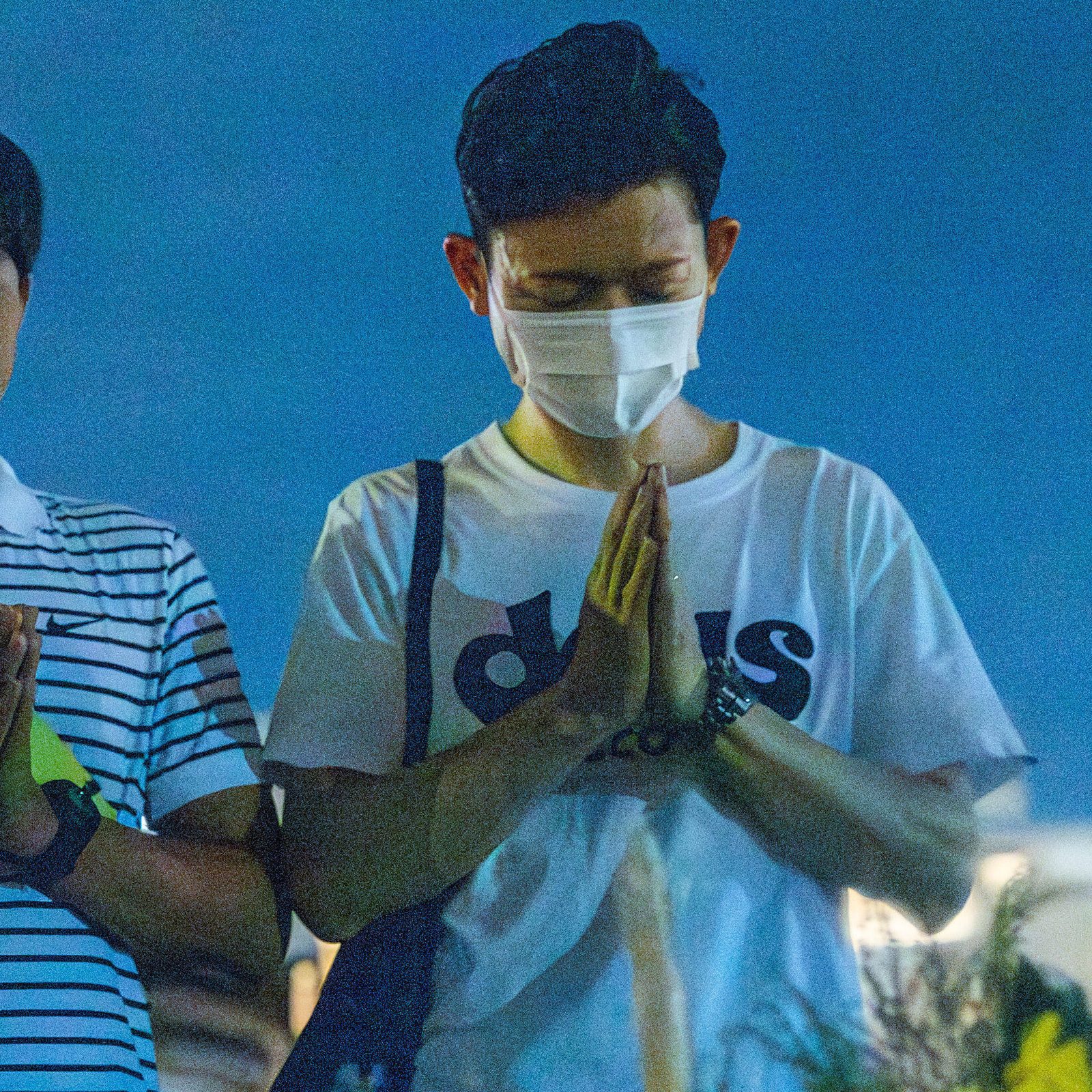 On the evening of Aug. 6, 2025, people line up in front of the Cenotaph for the A-bomb Victims at Hiroshima Peace Park to offer prayers. (Catholic Standard photo by Mihoko Owada)