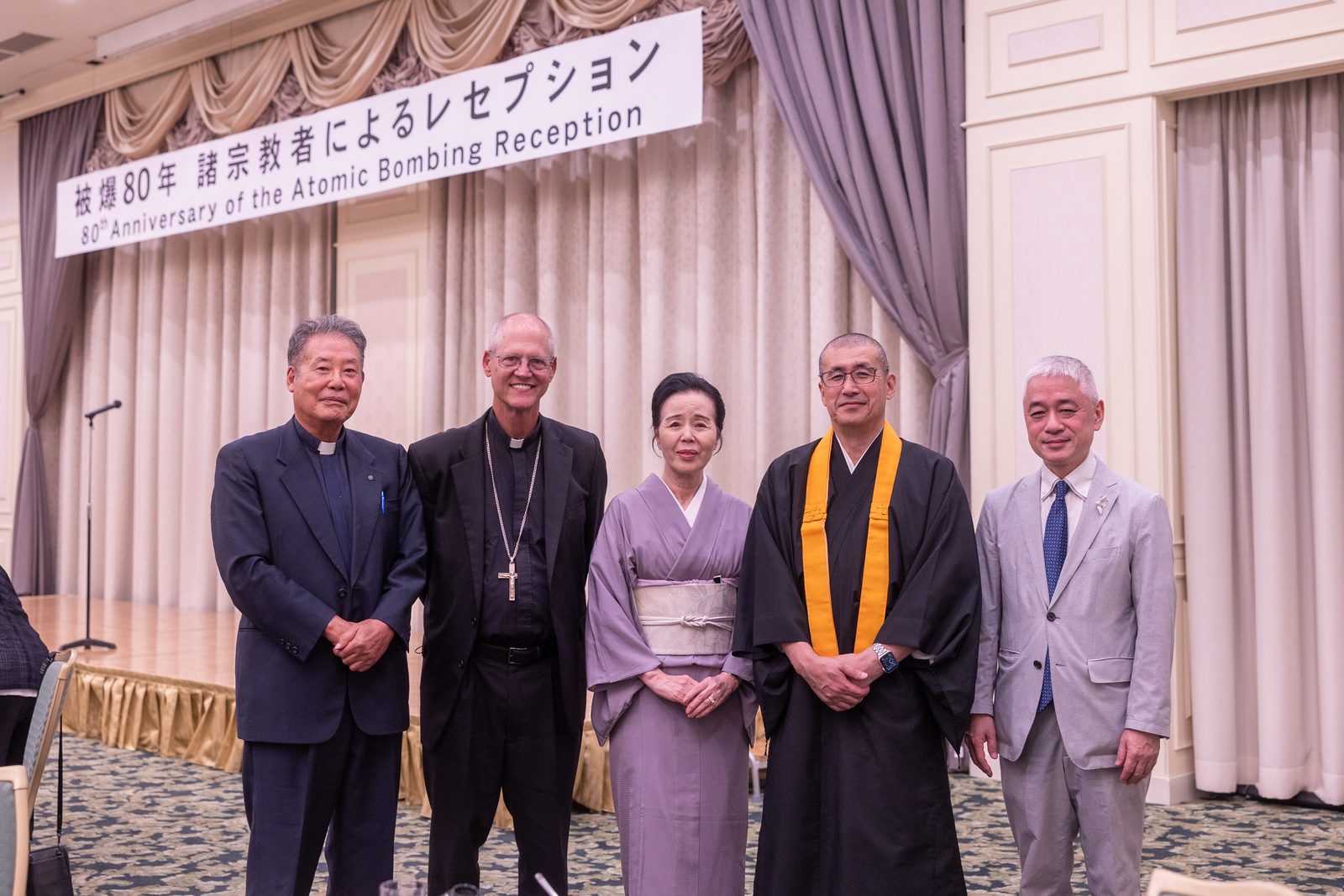 Archbishop Paul D. Etienne of Seattle (second from left) poses for photos with participants, including religious leaders, at a reception following the “Interreligious Symposium on Nuclear Issues and World Peace” on August 7, 2025, commemorating the 80th anniversary of the atomic bombings in Hiroshima and Nagasaki. (Catholic Standard photo by Mihoko Owada)