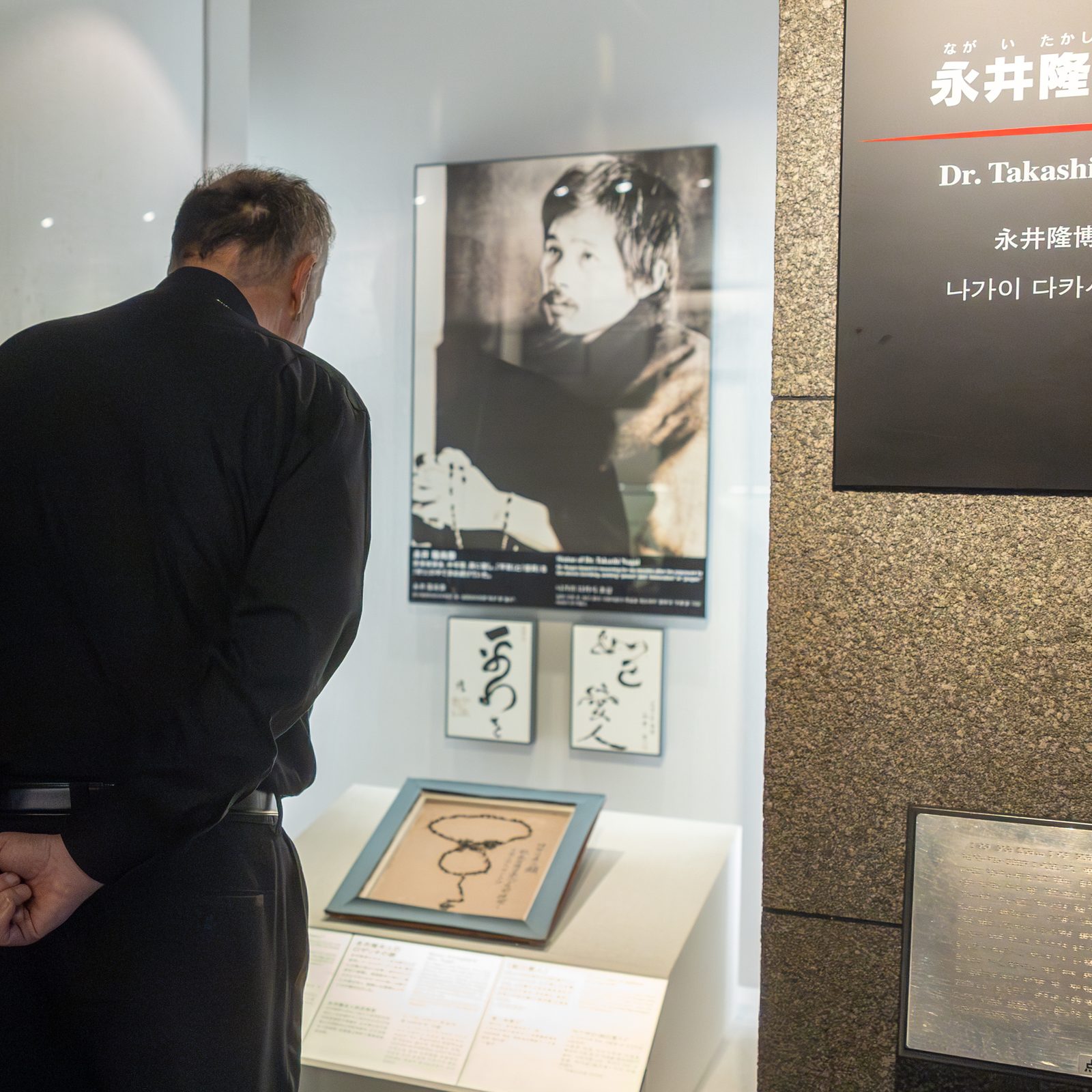 Cardinal Robert W. McElroy of Washington closely looks at the exhibition of Dr. Takashi Nagai during his visit to Nagasaki Atomic Bomb Museum on Aug. 8, 2025. Dr. Nagai, a physician and radiologist who cared for survivors in the aftermath of the U.S. atomic bombing of Nagasaki on Aug. 9, 1945, returned home to find the charred remains of his wife along with her melted rosary. Dr. Nagai, a convert to Catholicism, became a well-known advocate for peace and forgiveness until he died of leukemia in 1951. (Catholic Standard photo by Mihoko Owada)