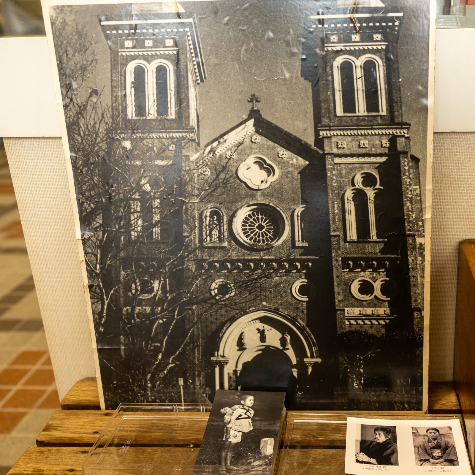 A photograph of the original Urakami Cathedral in Nagasaki, along with prayer cards, is on display in the “Atomic Bomb Relics Exhibition Room” on the first floor of the Urakami Cathedral church hall. (Catholic Standard photo by Mihoko Owada)