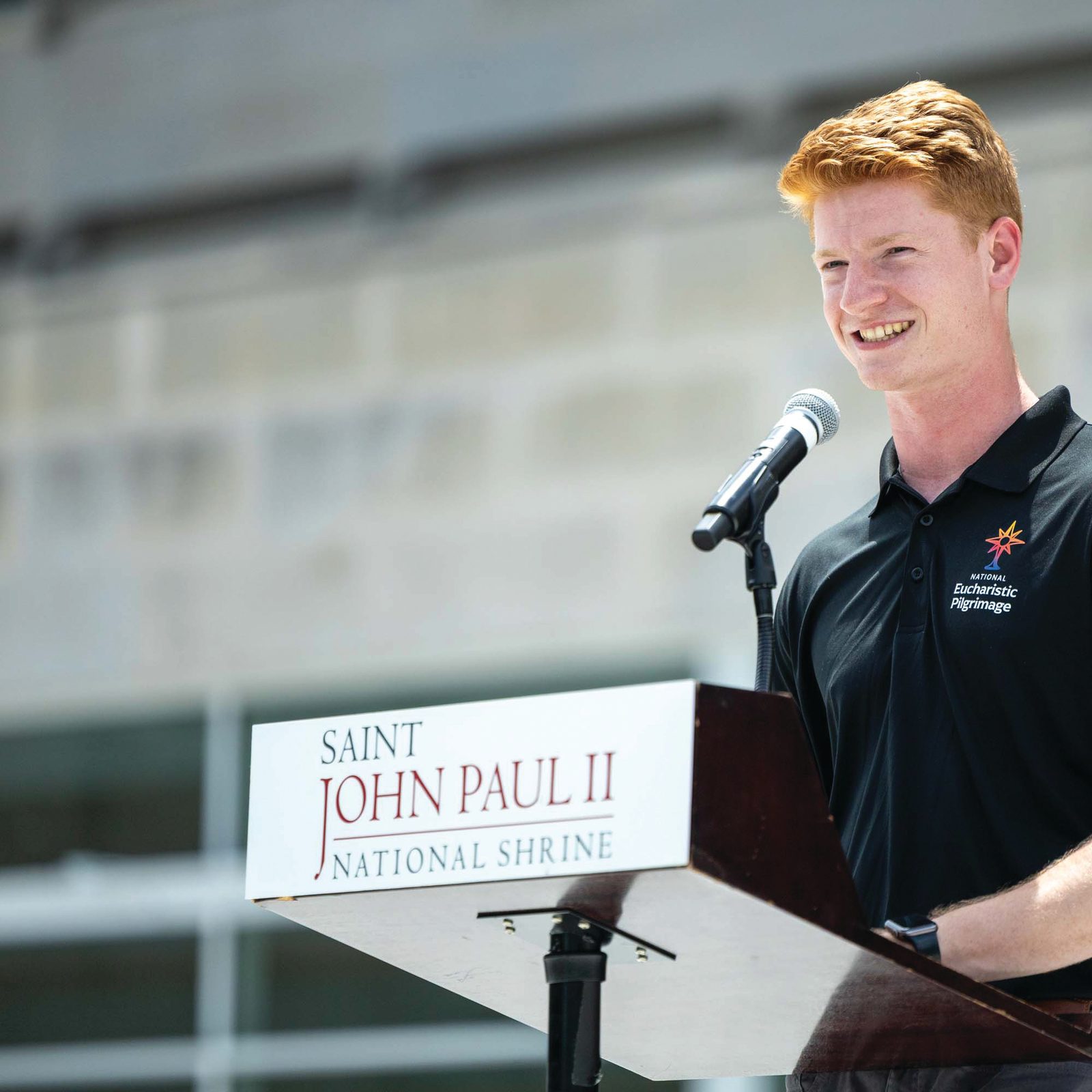 John Paul Flynn speaks about his experience as a perpetual pilgrim during a stop at the Saint John Paul II National Shrine in Washington on June 6 as part of the 2026 National Eucharistic Pilgrimage. Flynn, a student at The Catholic University of America, traveled with the pilgrimage for six weeks across most of the 13 original states during the nation’s 250th anniversary. (Catholic Standard photo by Mihoko Owada)