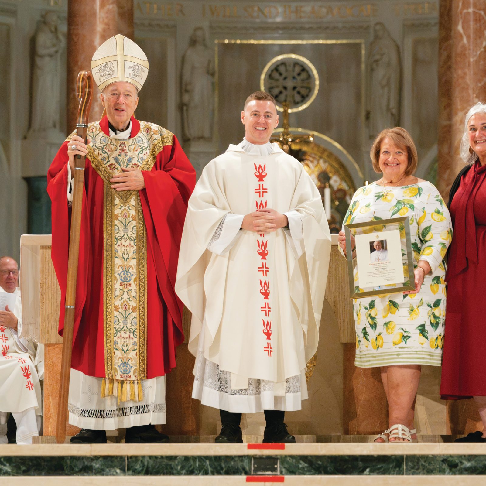 Holy Cross School in Garrett Park, Maryland, was honored for its 65th anniversary during the Opening of Schools Mass for the Roman Catholic Archdiocese of Washington on Aug. 24 at the Basilica of the National Shrine of the Immaculate Conception. From left to right are Washington Cardinal Robert W. McElroy; Father Stephen Wyble, the pastor of Holy Cross Parish; Lisa Maio Kane, the principal of Holy Cross School; and Kelly Branaman, the Secretary for Catholic Schools and Superintendent of Schools for the Archdiocese of Washington. (Catholic Standard photo by Nicole Olea)