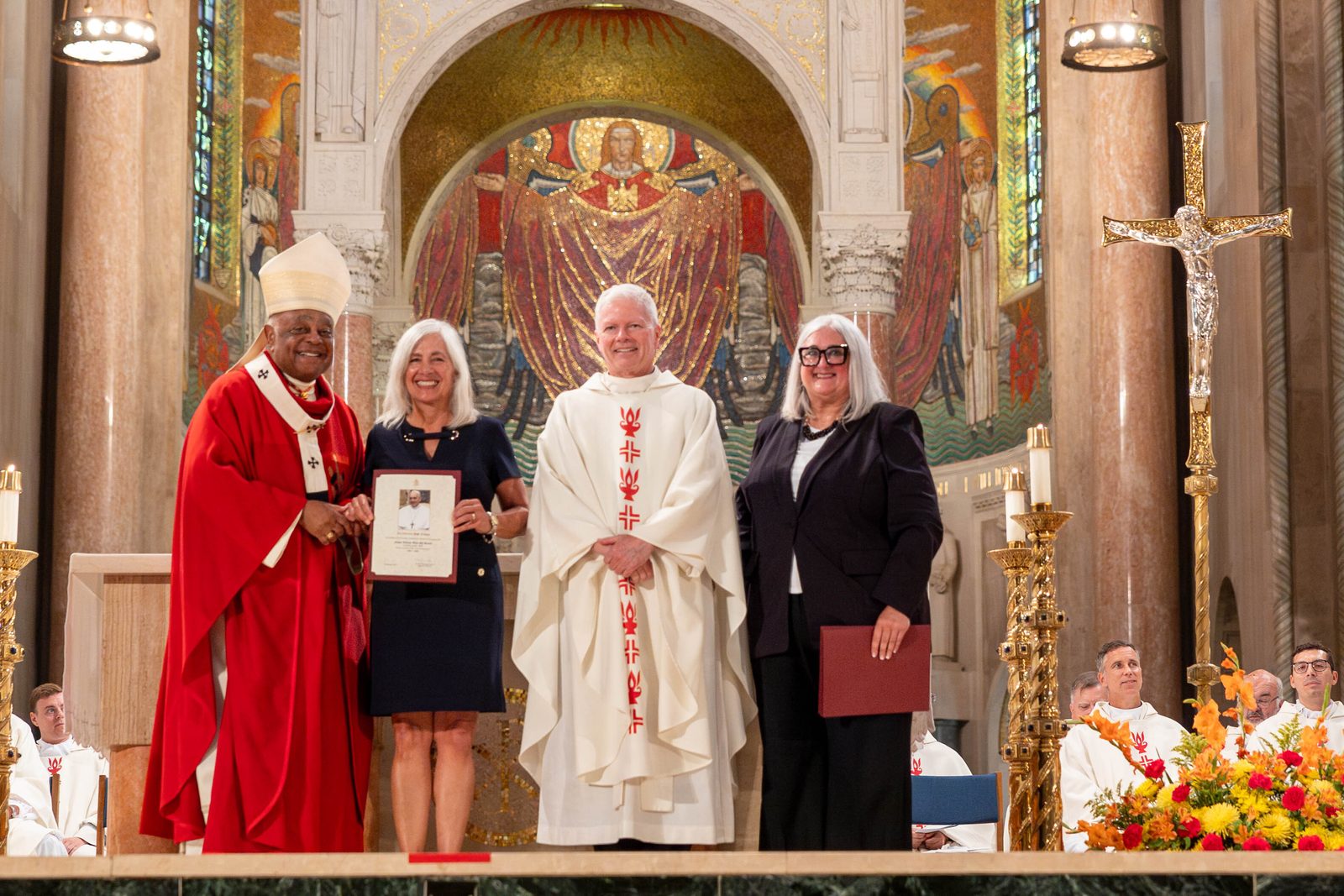 At the Opening of Schools Mass on Aug. 26 at the National Shrine, the local Catholic schools celebrating milestone anniversaries this year included Father Andrew White, S.J. School in Leonardtown, Maryland, which is marking its 70th anniversary. From left to right are Cardinal Wilton Gregory; Janet Szoch, the principal of Father Andrew White, S.J. School; Father David Beaubien, the pastor of St. Aloysius Parish in Leonardtown; and Kelly Branaman, the Secretary for Catholic Schools and Superintendent of Schools for The Roman Catholic Archdiocese of Washington. (Catholic Standard photo by Mihoko Owada)