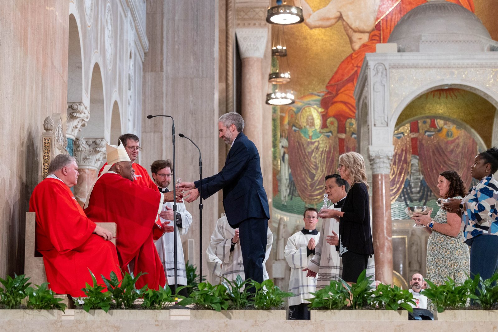 The offertory gift bearers at the Opening of Schools Mass on Aug. 26 at the National Shrine included new principals serving at Catholic schools in The Roman Catholic Archdiocese of Washington. In this photo, Cardinal Wilton Gregory receives offertory gifts from Kevin Somok from St. Jerome Academy in Hyattsville; followed by Michelle Truss from St. Philip the Apostle School in Camp Springs; Taylor Cotting from St. Raphael School in Rockville; and Dr. Anika Logan from St. Augustine Catholic School in Washington, D.C. (Catholic Standard photo by Mihoko Owada)