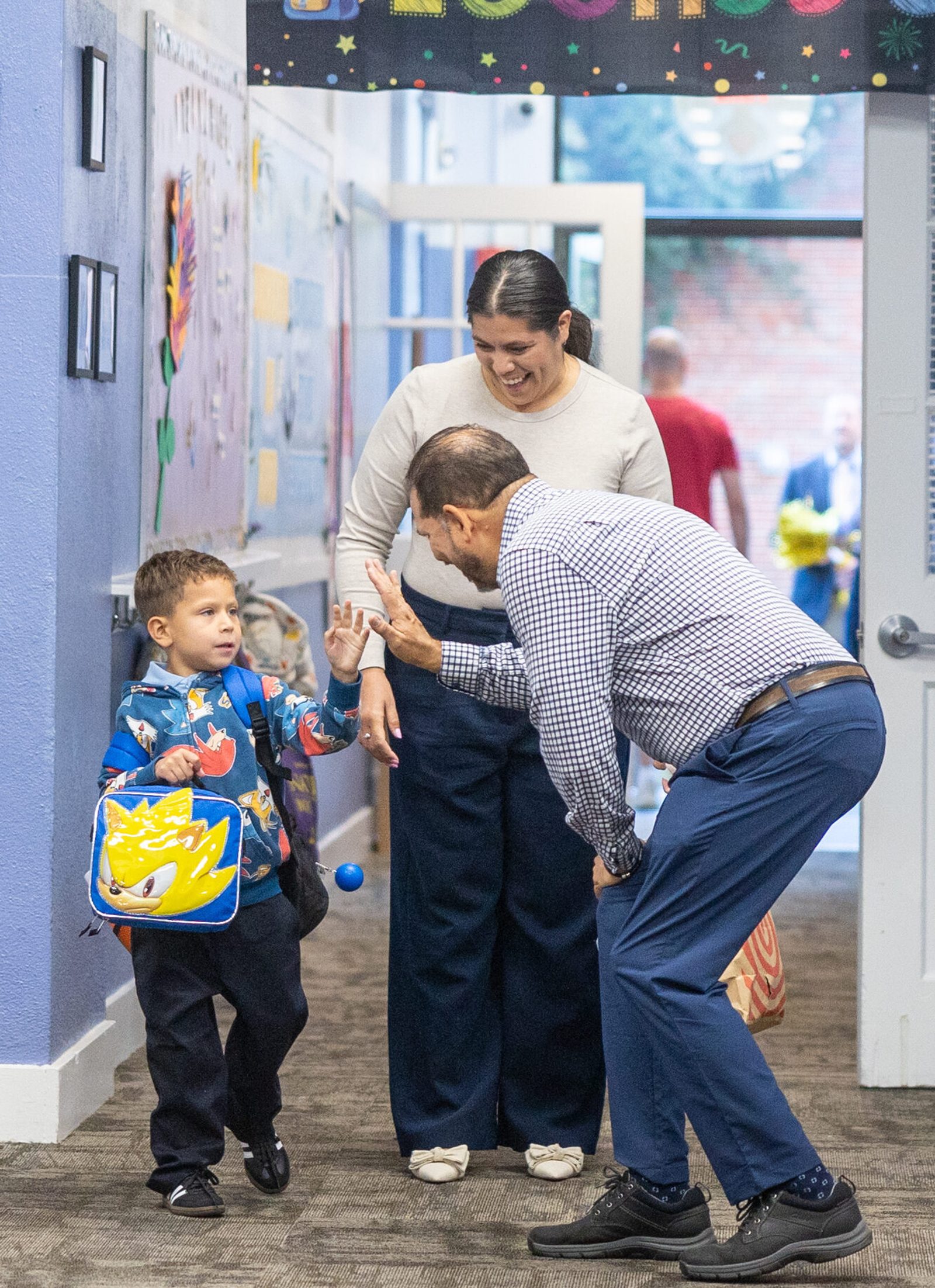 On August 26, the first day of school at Sacred Heart School in Washington, Jesus Camilo (after care administrator aide) greets a kindergarten student. (Catholic Standard photo by Mihoko Owada)