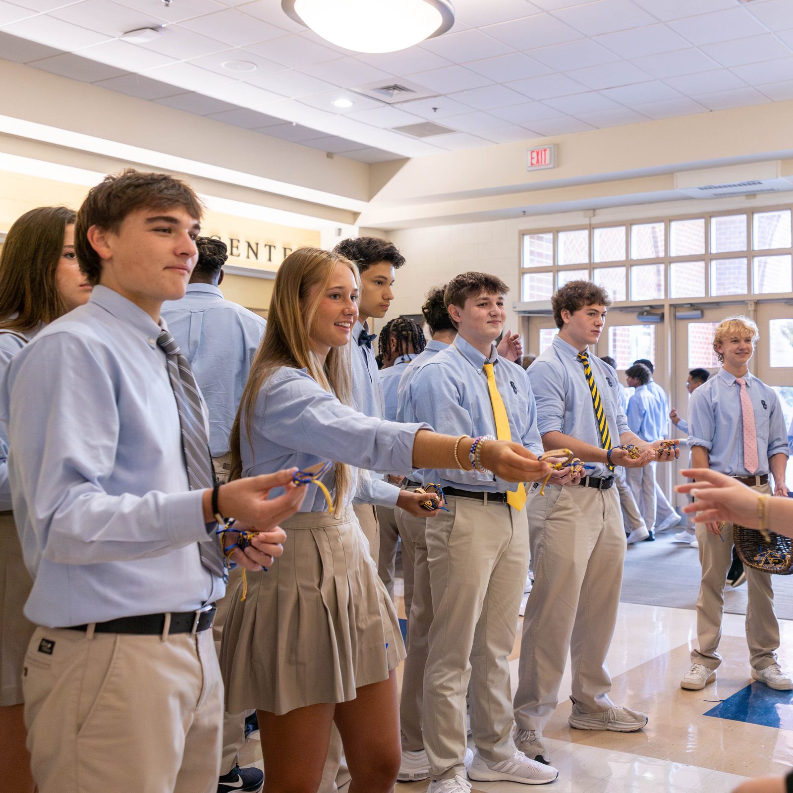 Before the opening school year Mass at Our Lady of Good Counsel High School in Olney, Maryland on Aug. 29, 2024, students hand out bracelets etched with the word “trust” to fellow students, reflecting the Xaverian value being emphasized at the school this year. (Catholic Standard photo by Mihoko Owada)