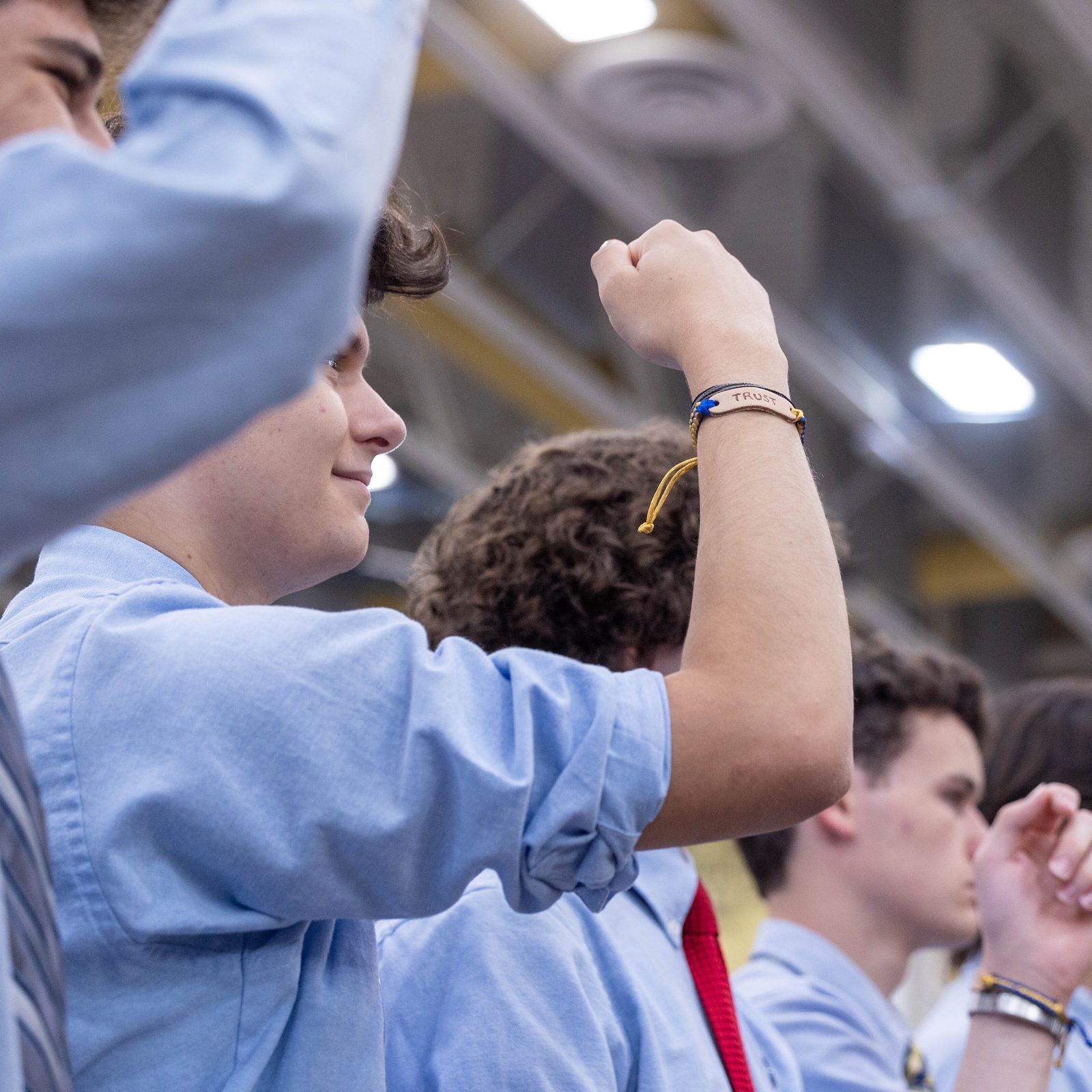 During the opening school year Mass on Aug. 29 at Our Lady of Good Counsel High School in Olney on Aug. 29, a student holds aloft his “trust” bracelet as the bracelets were being blessed by Cardinal Wilton Gregory. The word “trust” was etched on the handcrafted bracelets, reflecting the Xaverian value being emphasized at the school this year. (Catholic Standard photo by Mihoko Owada)