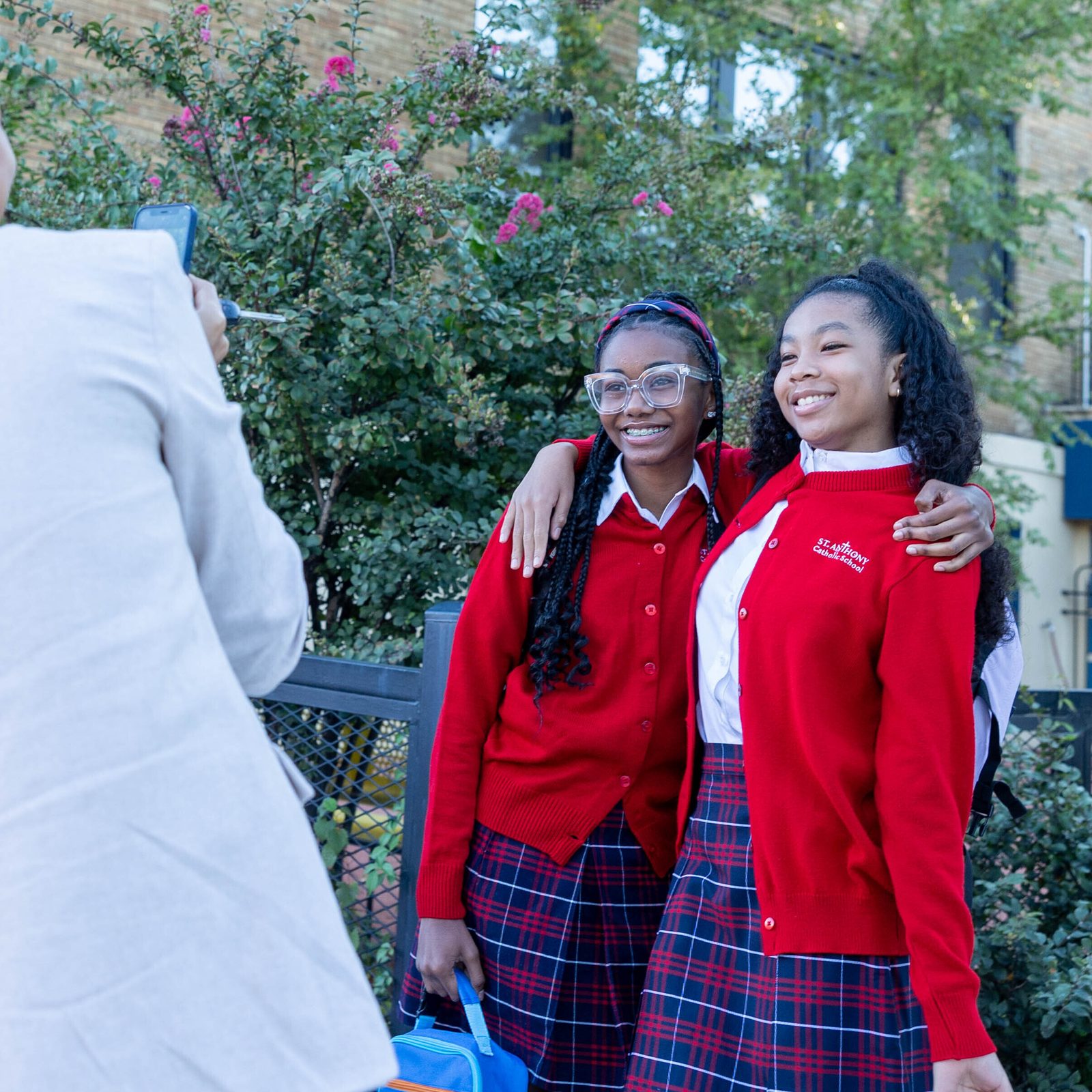 A woman takes photos of seventh graders Noah Haley-Gray and Logan Edwards (at right) on the first day of school at St. Anthony Catholic School in Washington on Sept. 3. (Catholic Standard photo by Mihoko Owada)