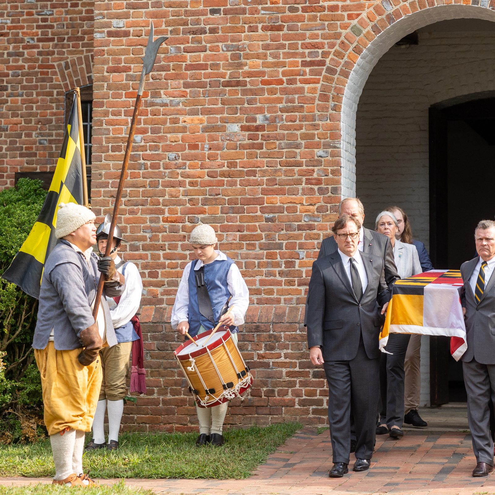 Eight honorary pallbearers who are descendants of 17th century Marylanders carry the pine coffin bearing the remains of eight young children from colonial-era Maryland at the beginning of a procession on Sept. 20, 2025 from the reconstructed State House of 1676 in Historic St. Mary’s City to the rebuilt 1667 Brick Chapel about one-half mile away. At the chapel, Baltimore Archbishop William E. Lori presided at a reinterment rite, marking the return of the remains of those eight young children at the site. In the early 1990s, the remains of 65 early Marylanders buried near the foundation of the original chapel were removed so they would not be damaged during the construction of the rebuilt chapel. (Catholic Standard photo by Mihoko Owada)