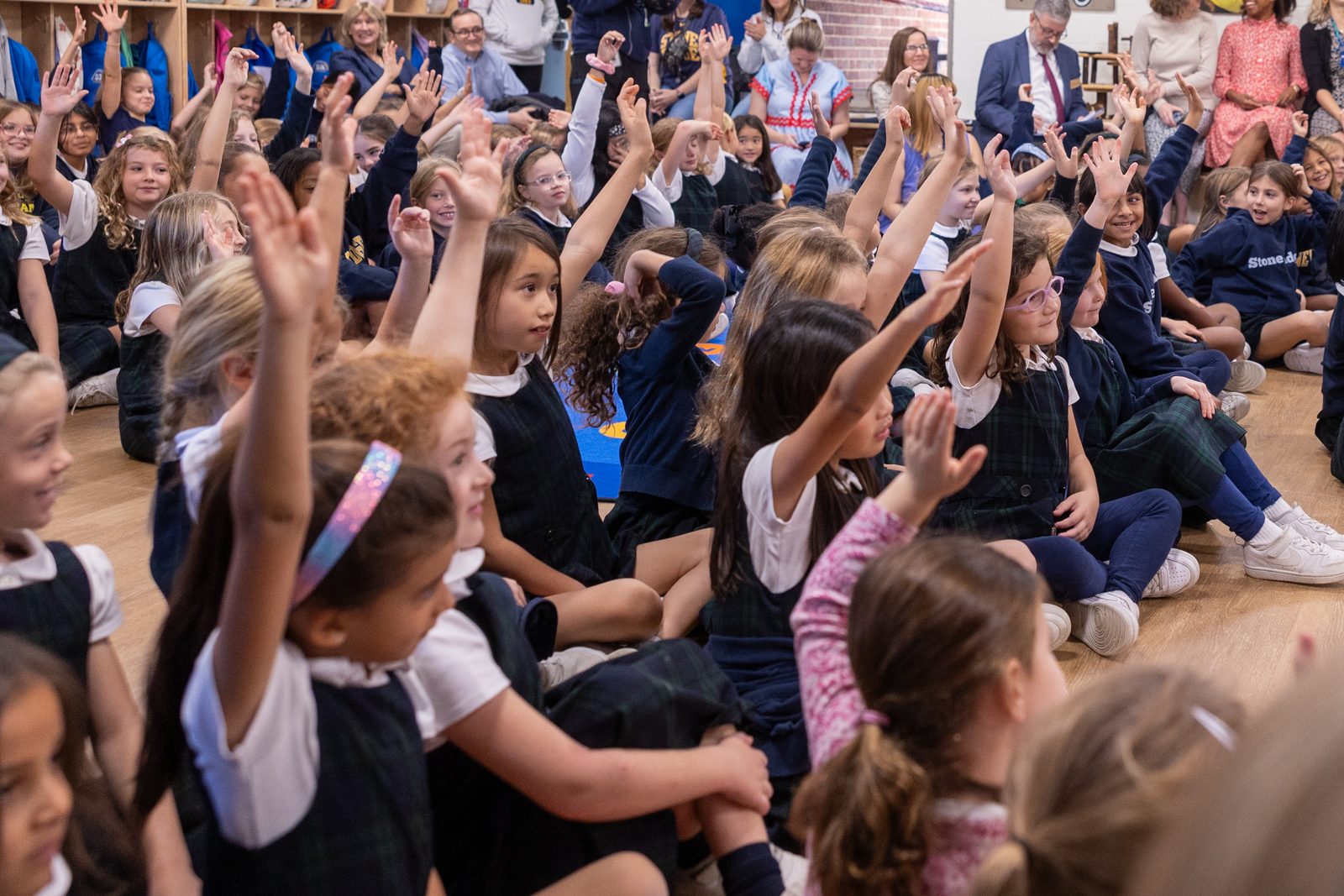 Stone Ridge Lower School students raise their hands to ask questions of Olympic champion swimmer Katie Ledecky during her visit to her alma mater, Stone Ridge School of the Sacred Heart in Bethesda, Maryland, on Oct. 22, 2024. (Catholic Standard photo by Mihoko Owada)