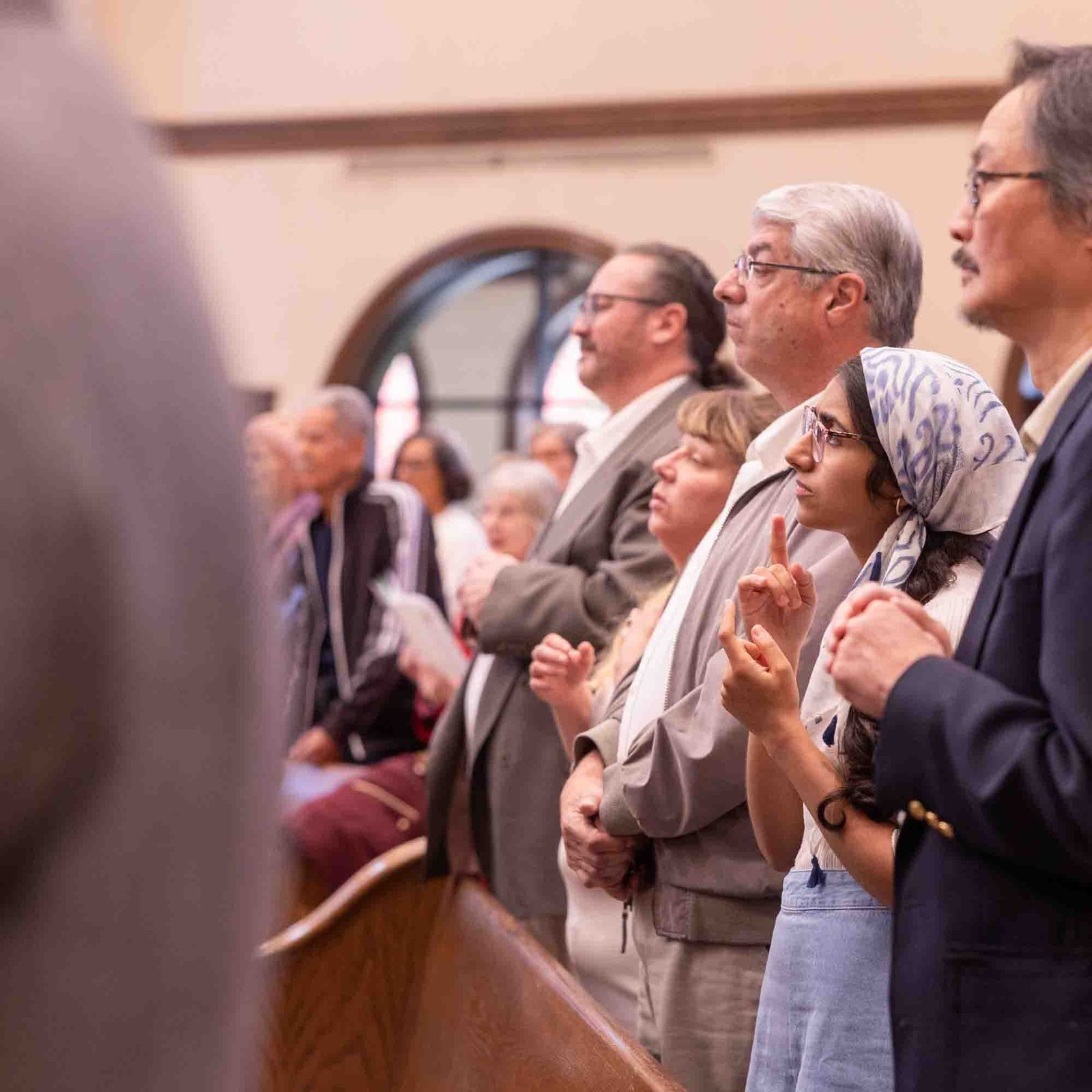 Madeeha Mirza, second from right, a graduate student at Gallaudet University in Washington, uses American Sign Language as she participates in the White Mass on Oct. 26 at Our Lady of Mercy Church in Potomac. From left to right are Hector Reyes, Jodi Ferrell, Tom Ferrell, Madeeha Mirza and Peter Un. (Catholic Standard photo by Mihoko Owada)