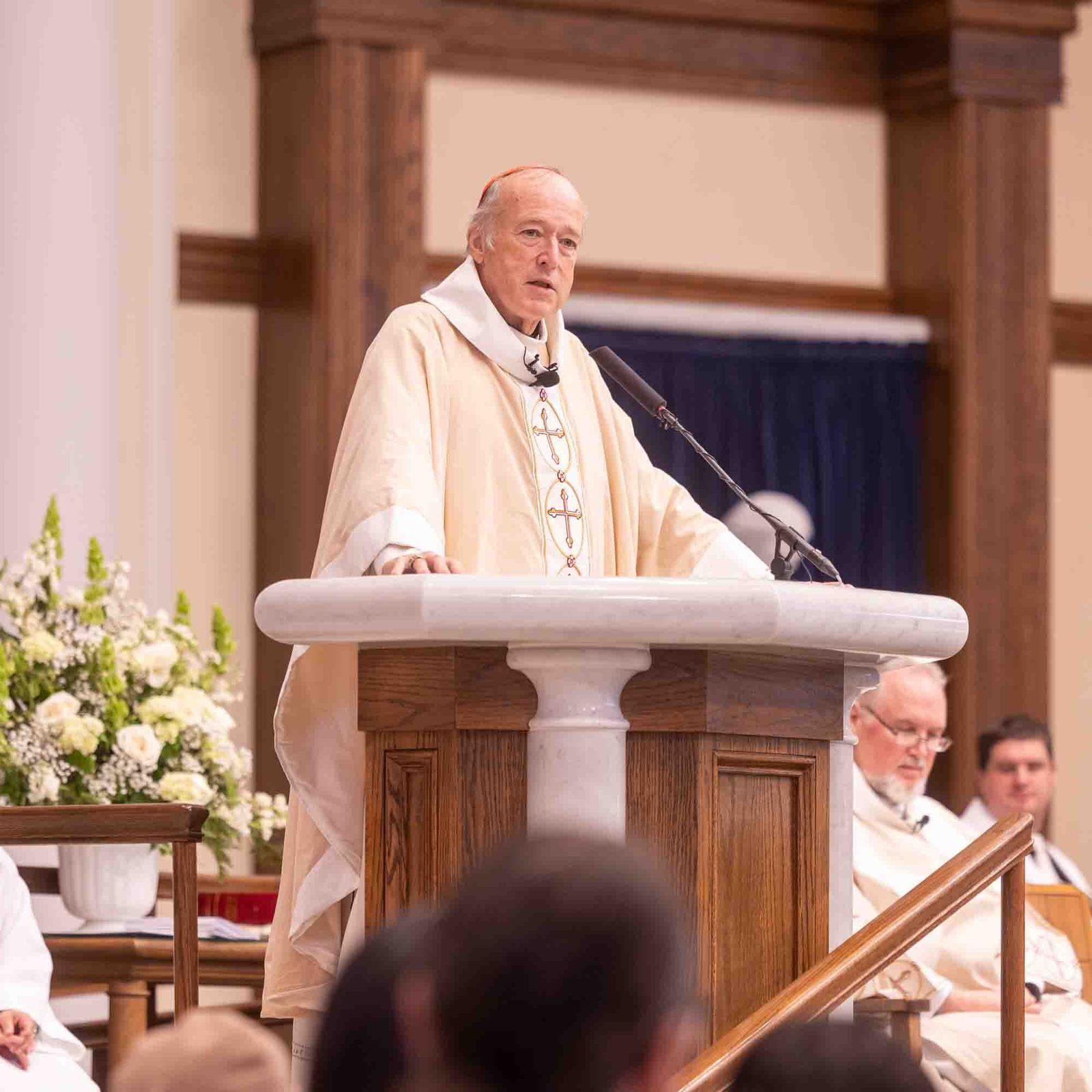 Cardinal Robert W. McElroy gives the homily at the Archdiocese of Washington’s annual White Mass on Oct. 26 at Our Lady of Mercy Church in Potomac. The Mass celebrates the giftedness and the full participation in the Church of people from the Deaf community and persons and their families living with disabilities. Seated at left are altar servers Willie Caro and Maria Guadalupe. (Catholic Standard photo by Mihoko Owada)