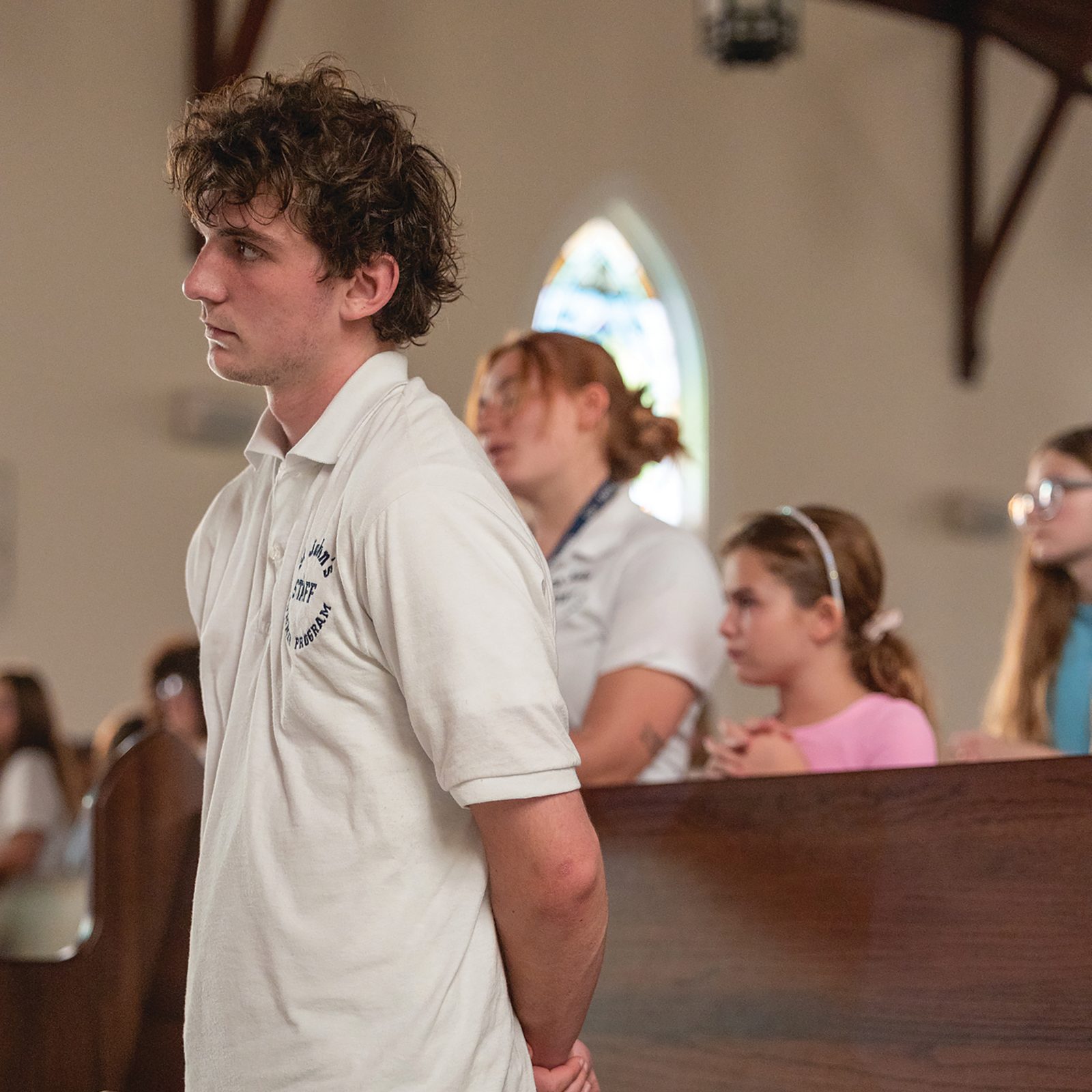 Josh Johnson, a staff member of the St. John’s Summer Program at St. John Francis Regis Parish in Hollywood, Maryland, kneels in prayer on July 21 during Eucharistic Adoration in the church. (Catholic Standard photo by Mihoko Owada)