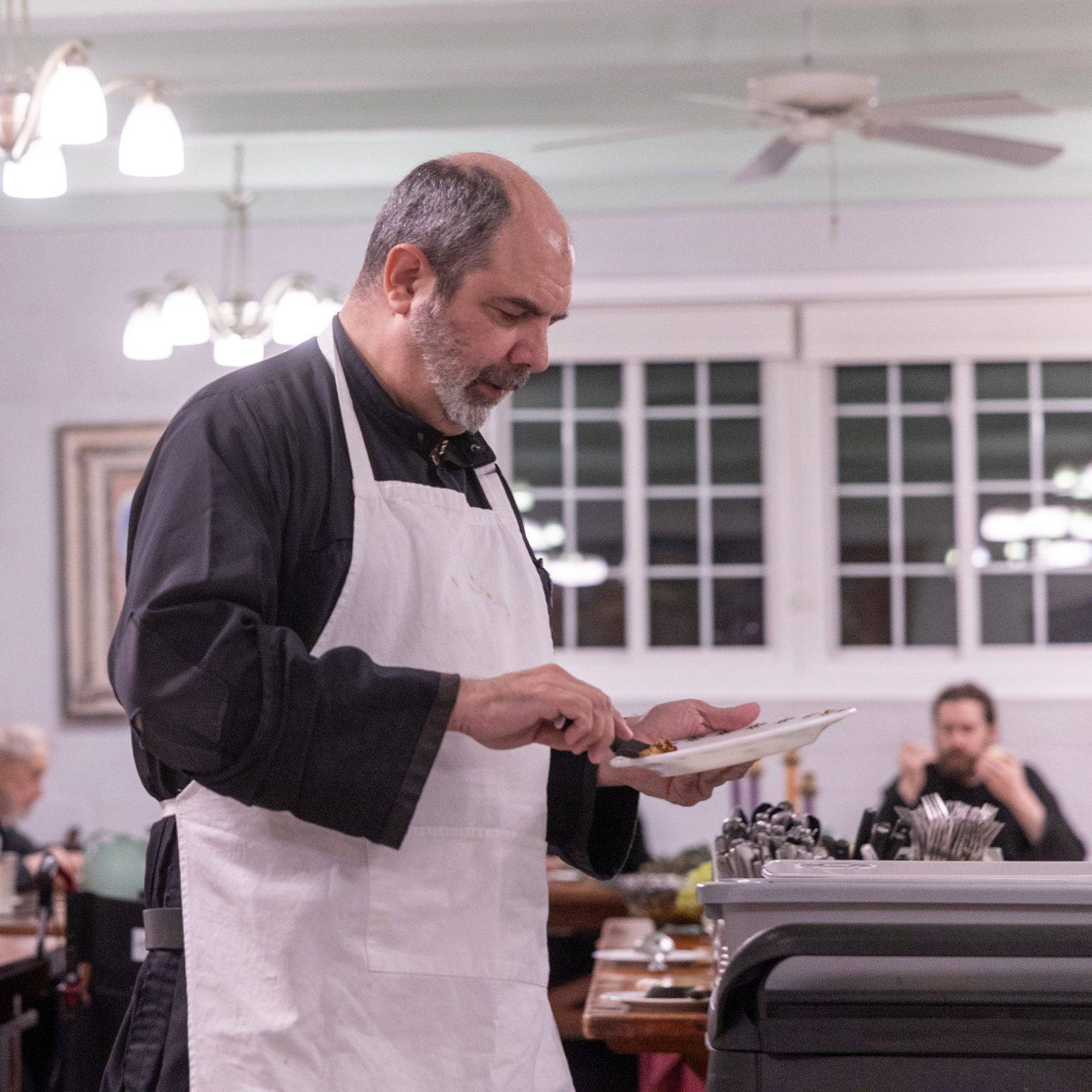 Benedictine Father Ignacio Gonzalez cleans dishes after the monks finish their meals at their silent dinner in the refectory at St. Anselm’s Abbey in Washington on Dec. 11, 2024. (Catholic Standard photos by Mihoko Owada)