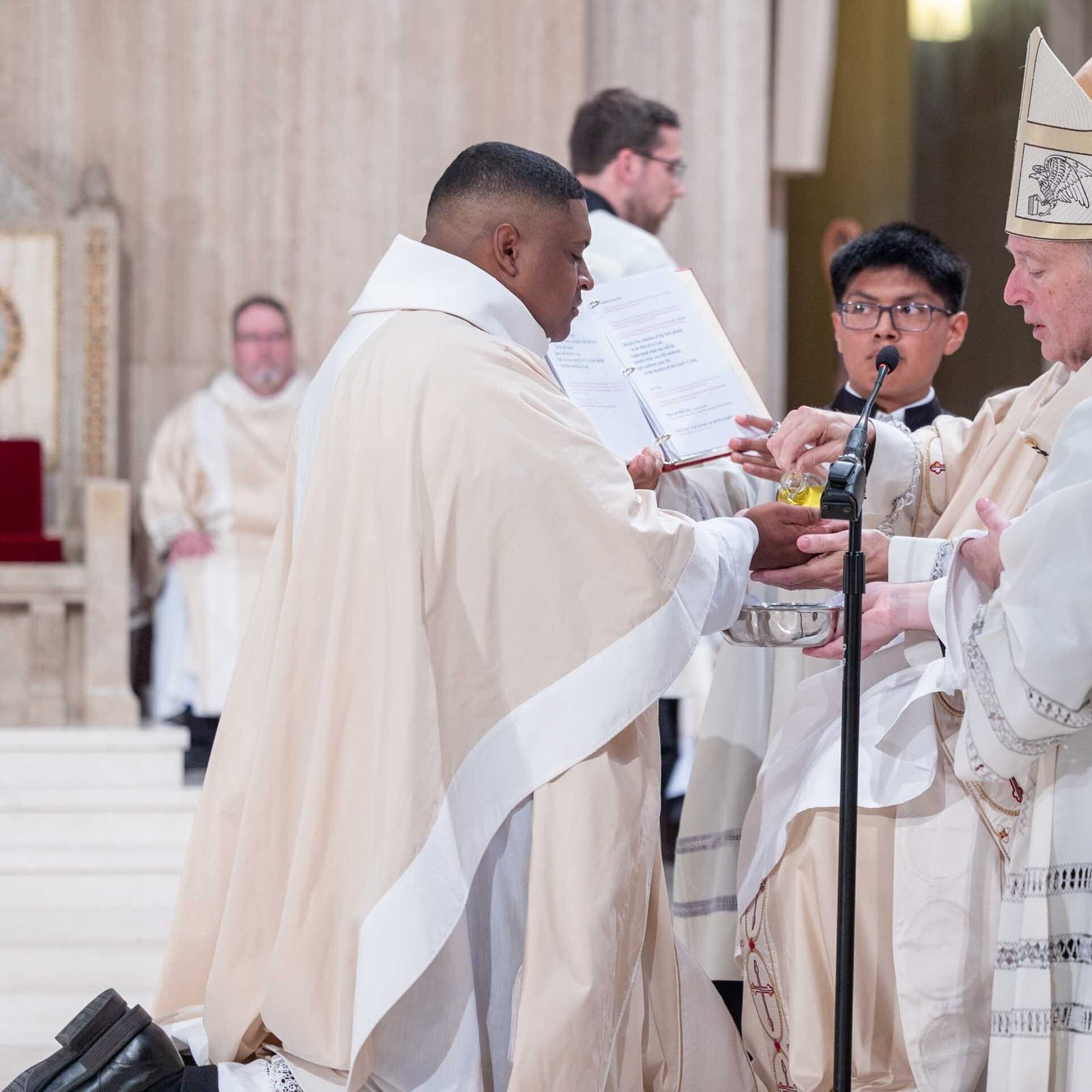 During the Mass of Priesthood Ordination at the Basilica of the National Shrine of the Immaculate Conception on June 20, 2026 for the five new priests of the Roman Catholic Archdiocese of Washington, newly ordained Father Jessiah Rojas in the photo above has his hands anointed with chrism by Cardinal Robert W. McElroy. In the photo below, newly ordained Father Pedro López has his hands anointed by the cardinal. (Catholic Standard photo by Mihoko Owada)