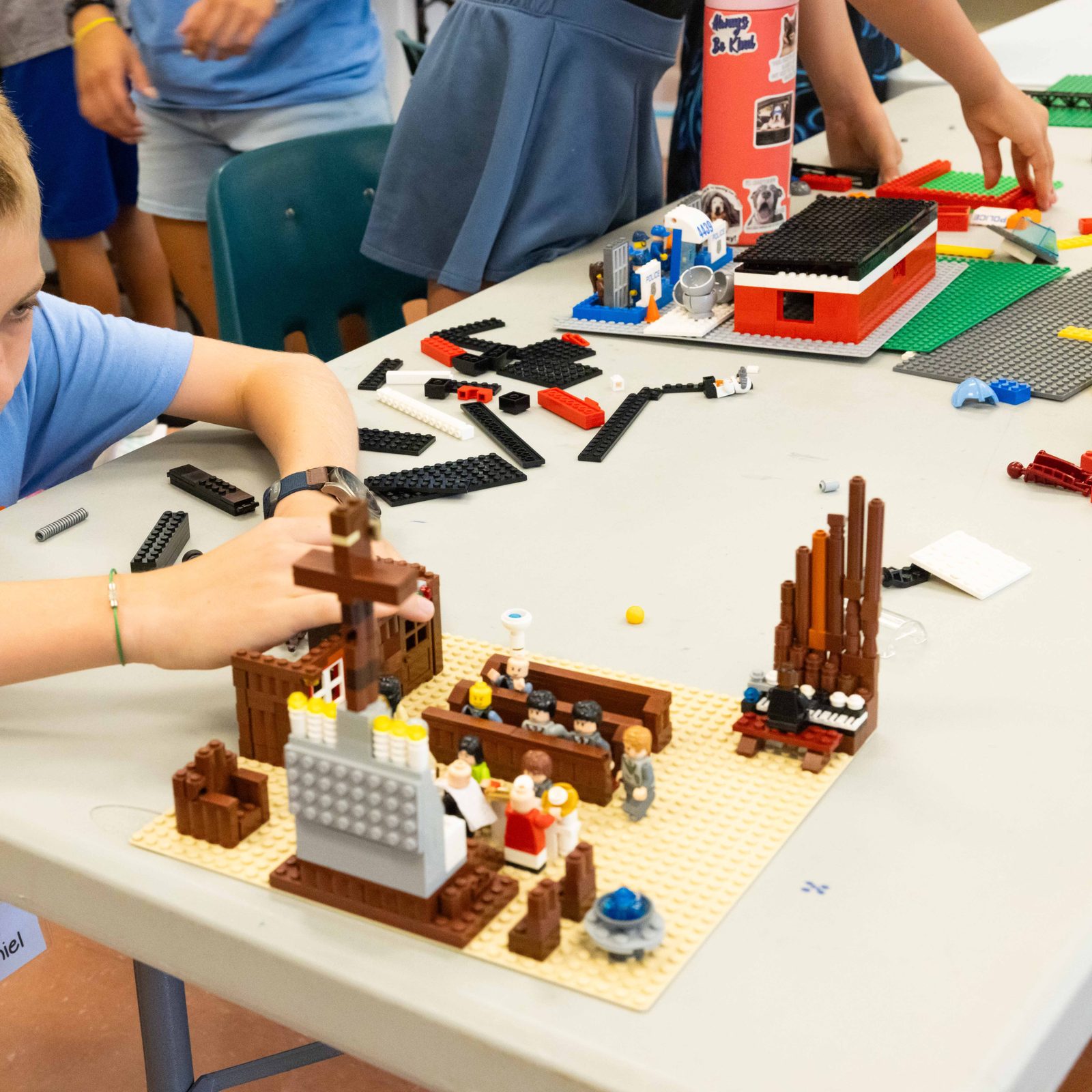 During a LEGO masters activity at the Rockville Catholic Summer Program on Aug. 5 at St. Patrick’s Parish, volunteer Daniel Rottkamp works on a LEGO church scene that includes an altar, an organ, and figures in pews and other figures receiving Communion. (Catholic Standard photo by Andrew Biraj)