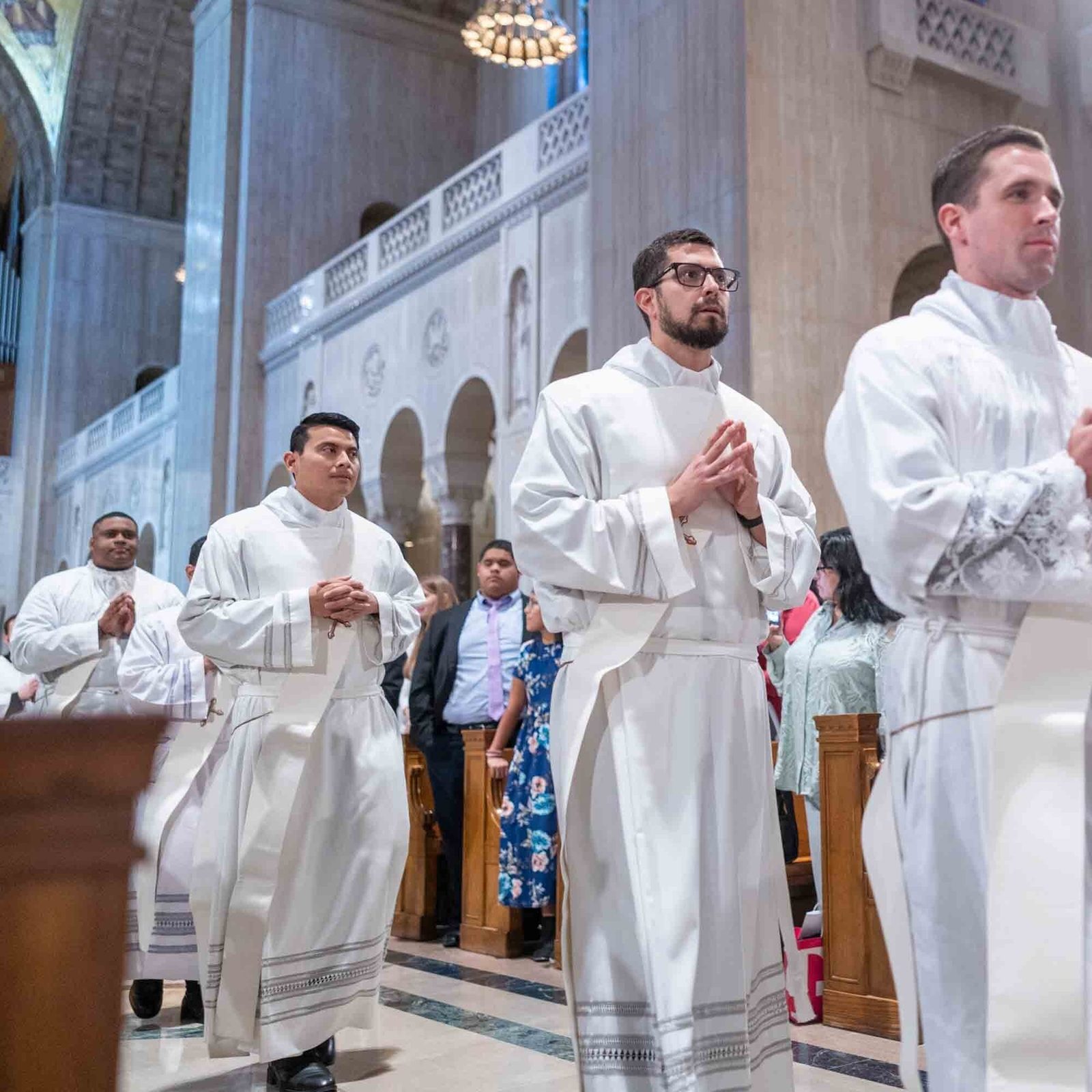 The men about to be ordained as new priests for the Roman Catholic Archdiocese of Washington, including from left, Deacon Jessiah S Rojas, Deacon Pedro Antonio López Berrios, Deacon Federico José Mariano, and Deacon Brendan Basil Parlett join the opening procession at the Mass for the Ordination of Priests on June 20, 2026 at the Basilica of the National Shrine of the Immaculate Conception. Also joining the procession at the Mass where he would be ordained to the priesthood was Deacon David Ezequiel Narváez Vargas. (Catholic Standard photo by Mihoko Owada)