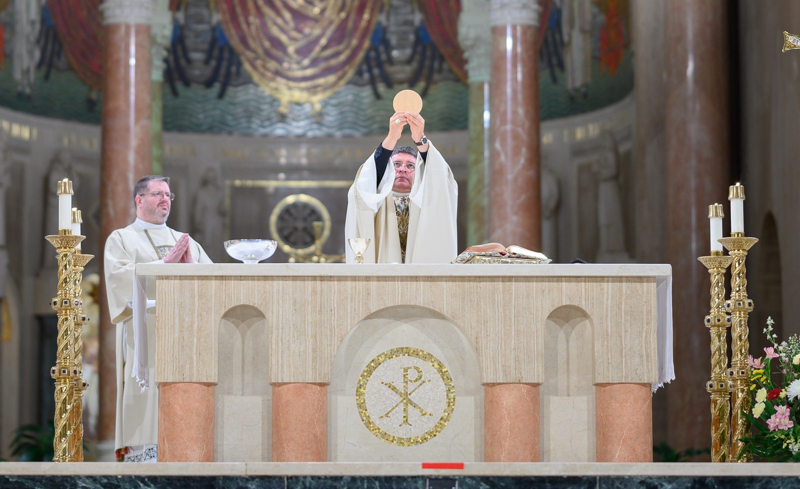 Washington Auxiliary Bishop Evelio Menjívar elevates the Eucharist during the Annual Wedding Mass to celebrate the vocation of marriage at the Basilica of the National Shrine of the Immaculate Conception on Feb. 8, 2025. Deacon Charles Huber at left assisted at the Mass. The liturgy sponsored by the Office of Family Life of The Roman Catholic Archdiocese of Washington honored the sacrament of marriage as a path to holiness. (Catholic Standard photo by Nicole Olea)