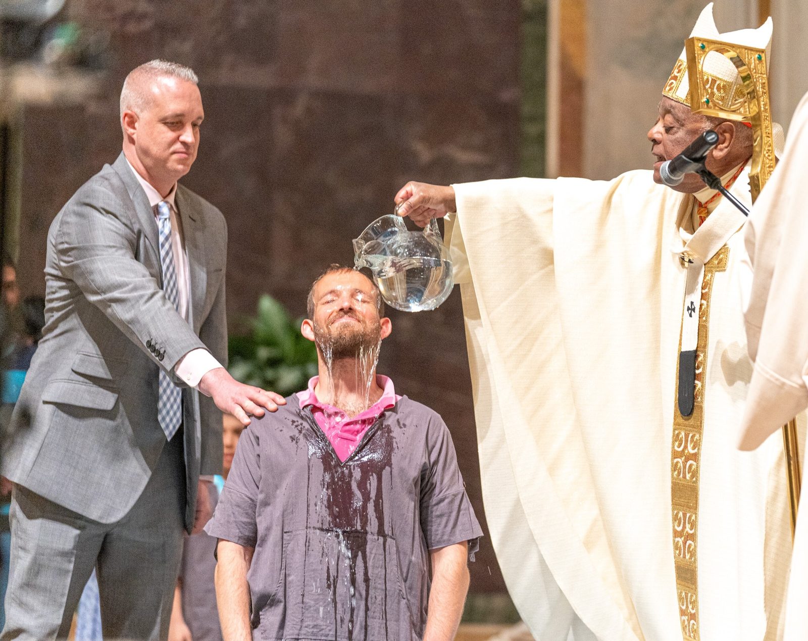 In this photo, Cardinal Wilton Gregory baptizes Andre Gouyet during the Easter Vigil on April 8, 2023 at the Cathedral of St. Matthew the Apostle. This photo won a first place award for best photograph of a sacrament in the 2024 Catholic Media Awards competition of the Catholic Media Association. (Catholic Standard photo by Mihoko Owada)