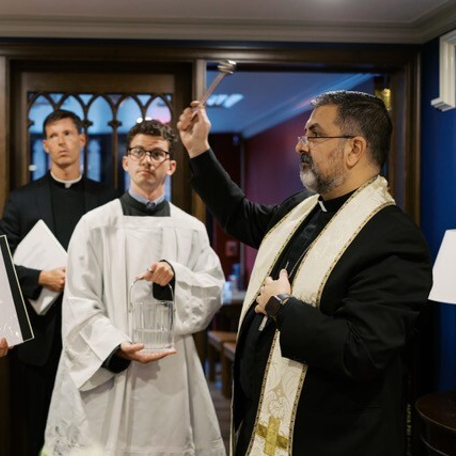 Washington Auxiliary Bishop Juan Esposito, at right, blesses the new parish office and Frassati Chapel for Immaculate Conception Parish in Washington, D.C., on Aug. 9, 2025. At center are Father Charles Gallagher, the pastor of Immaculate Conception Parish, and Chris Levesque, the liturgical assistant in the Office of Worship of the Roman Catholic Archdiocese of Washington. The altar server at left is Victor Juarez Torrez. (Photo for Immaculate Conception Parish by Steve Dalgetty)
