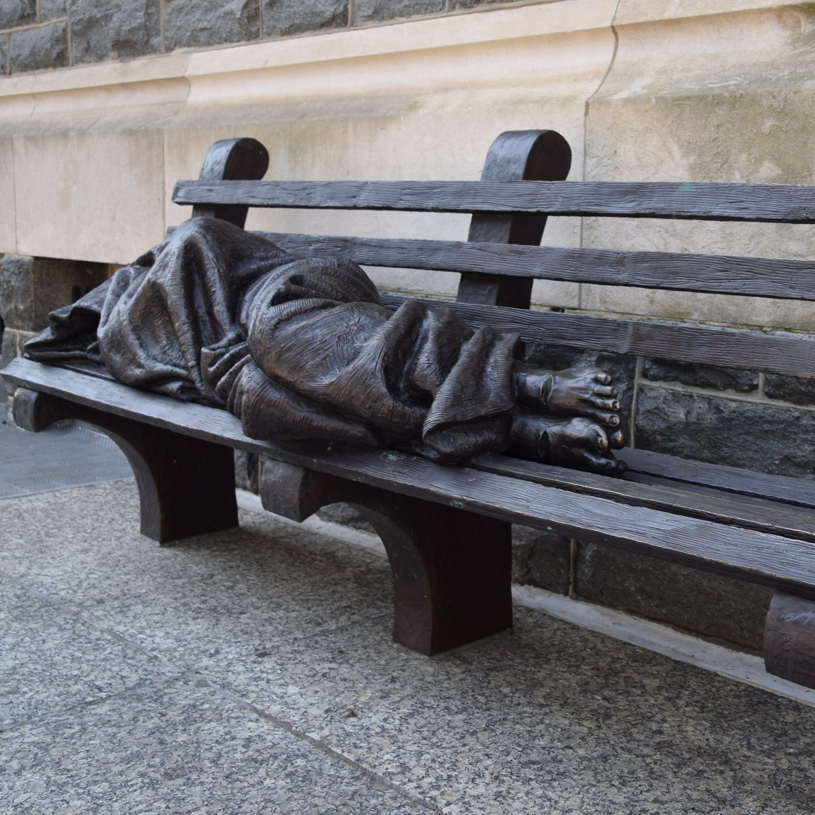 A bronze sculpture by artist Timothy Schmalz titled “Homeless Jesus” outside the headquarters of Catholic Charities of the Archdiocese of Washington shows a figure wrapped in a blanket lying on a park bench with nail marks in his feet, symbolizing something that St. Teresa of Calcutta often emphasized, the importance of recognizing Jesus in the poorest of the poor. (Photo courtesy of Catholic Charities)
