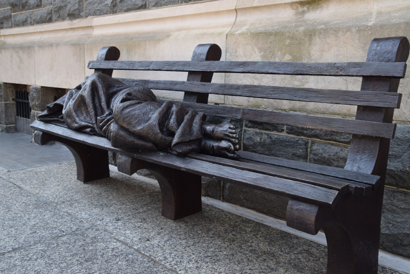 A bronze sculpture by artist Timothy Schmalz titled “Homeless Jesus” outside the headquarters of Catholic Charities of the Archdiocese of Washington shows a figure wrapped in a blanket lying on a park bench with nail marks in his feet, symbolizing something that St. Teresa of Calcutta often emphasized, the importance of recognizing Jesus in the poorest of the poor. (Photo courtesy of Catholic Charities)
