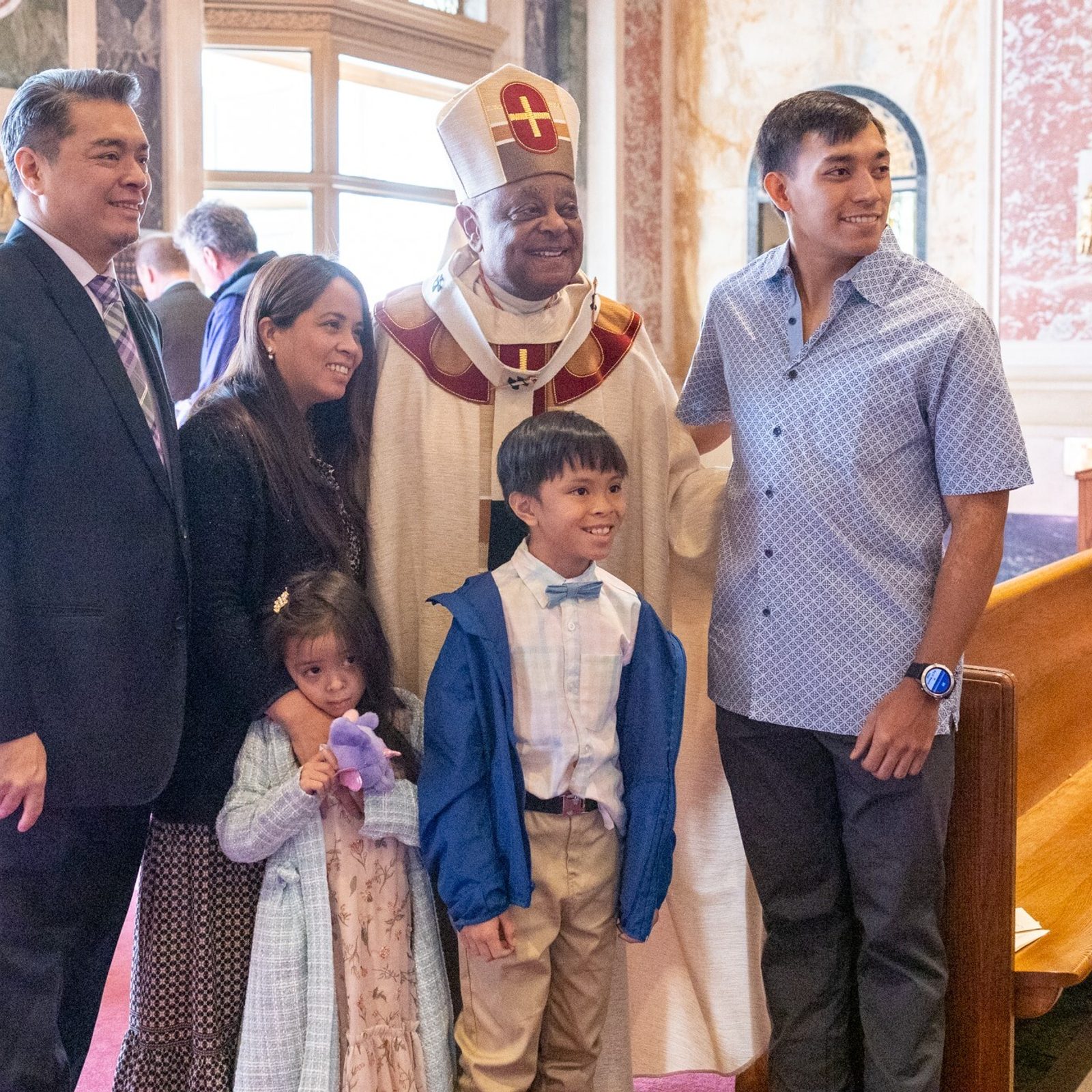 After an Easter Sunday Mass on March 31 at St. Matthew’s Cathedral in Washington, Cardinal Wilton Gregory poses for a photo with a family. (Catholic Standard photo by Mihoko Owada)