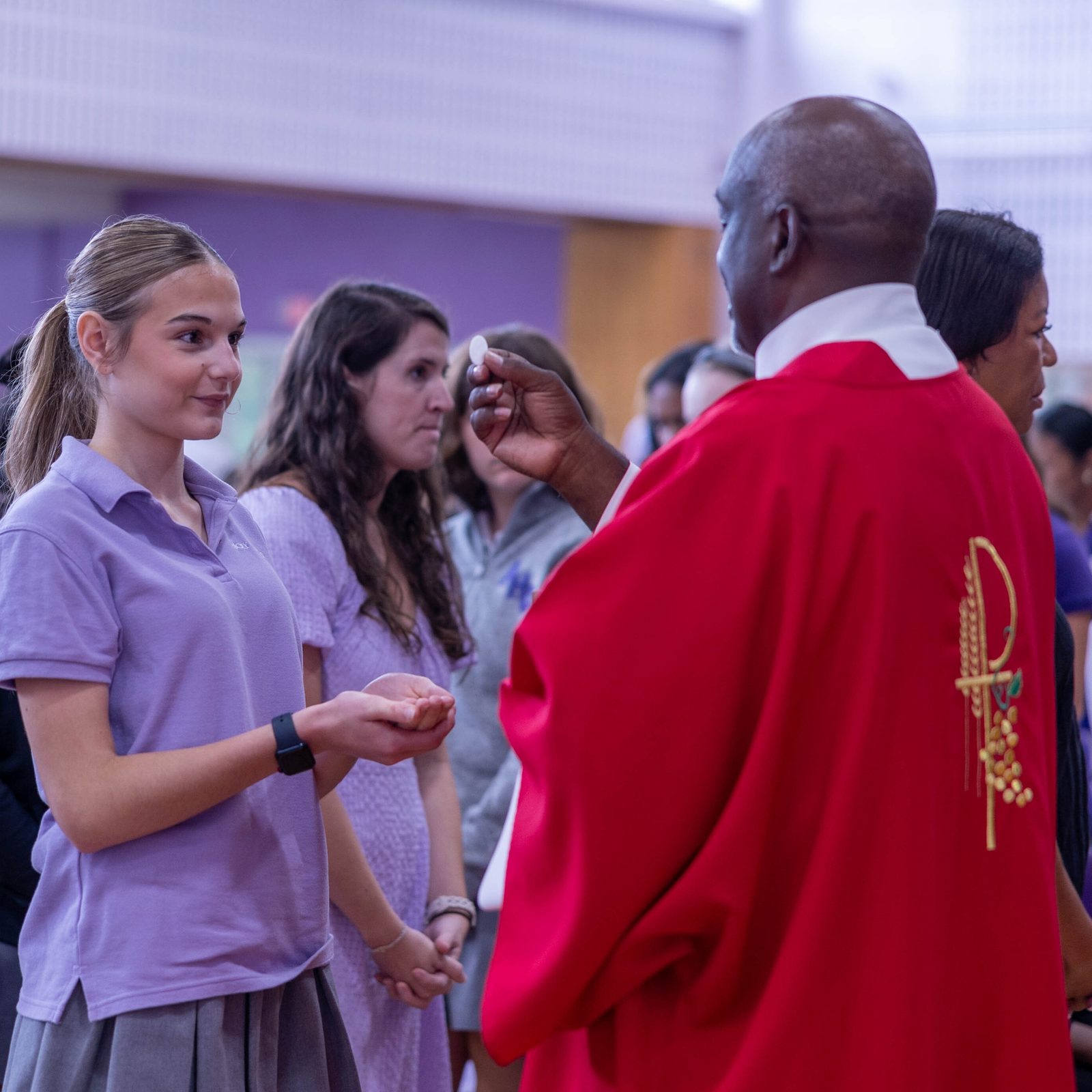 Deacon Keith Somerville gives Communion to a student during a school-wide Mass celebrated by Washington Cardinal Wilton Gregory on Sept. 13, 2024 to mark the Feast of the Exaltation of the Holy Cross. Deacon Somerville’s daughter Karlena is a freshman at Holy Cross. (Catholic Standard photo by Mihoko Owada)