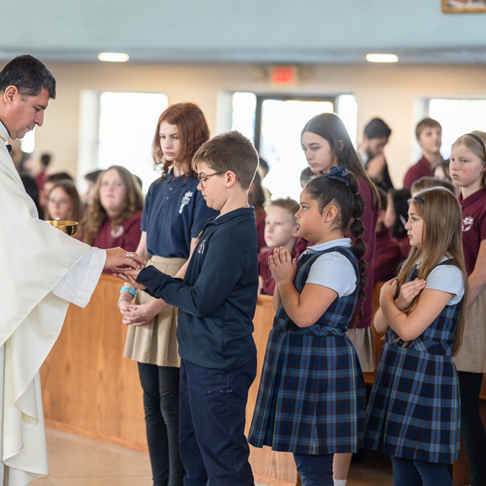 James Stauffer, a third grader from Father Andrew White, S.J. School in Leonardtown, receives Communion from Washington Auxiliary Bishop Evelio Menjivar during a Catholic Schools Week Mass for St. Mary’s County Catholic schools on Jan. 22, 2026 at Immaculate Heart of Mary Church in Lexington Park, Maryland. The students behind him in the Communion line are Arabella Anderson and Wren Gatton, both third graders at Father Andrew White School. The students in the Communion line next to them are Paige Strzok, Avery Skinner and Ella Armsworthy, who are seventh graders from St. John’s School in Hollywood. (Catholic Standard photos by Nicole Olea)
