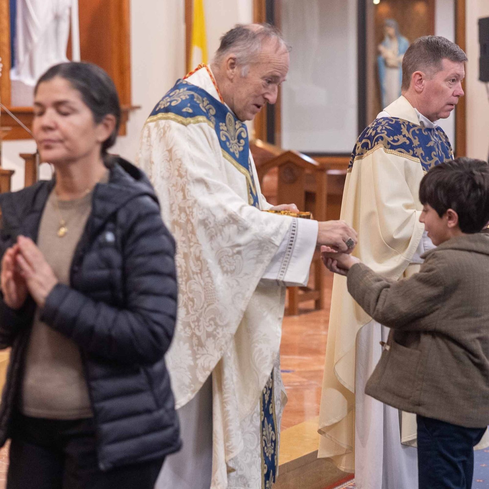 Henry Meilak, a student at Our Lady of Lourdes School in Bethesda, receives Communion from Washington Cardinal Robert W. McElroy during a Feb. 11 Mass at the church commemorating the parish’s 100th anniversary. (Catholic Standard photo by Mihoko Owada)