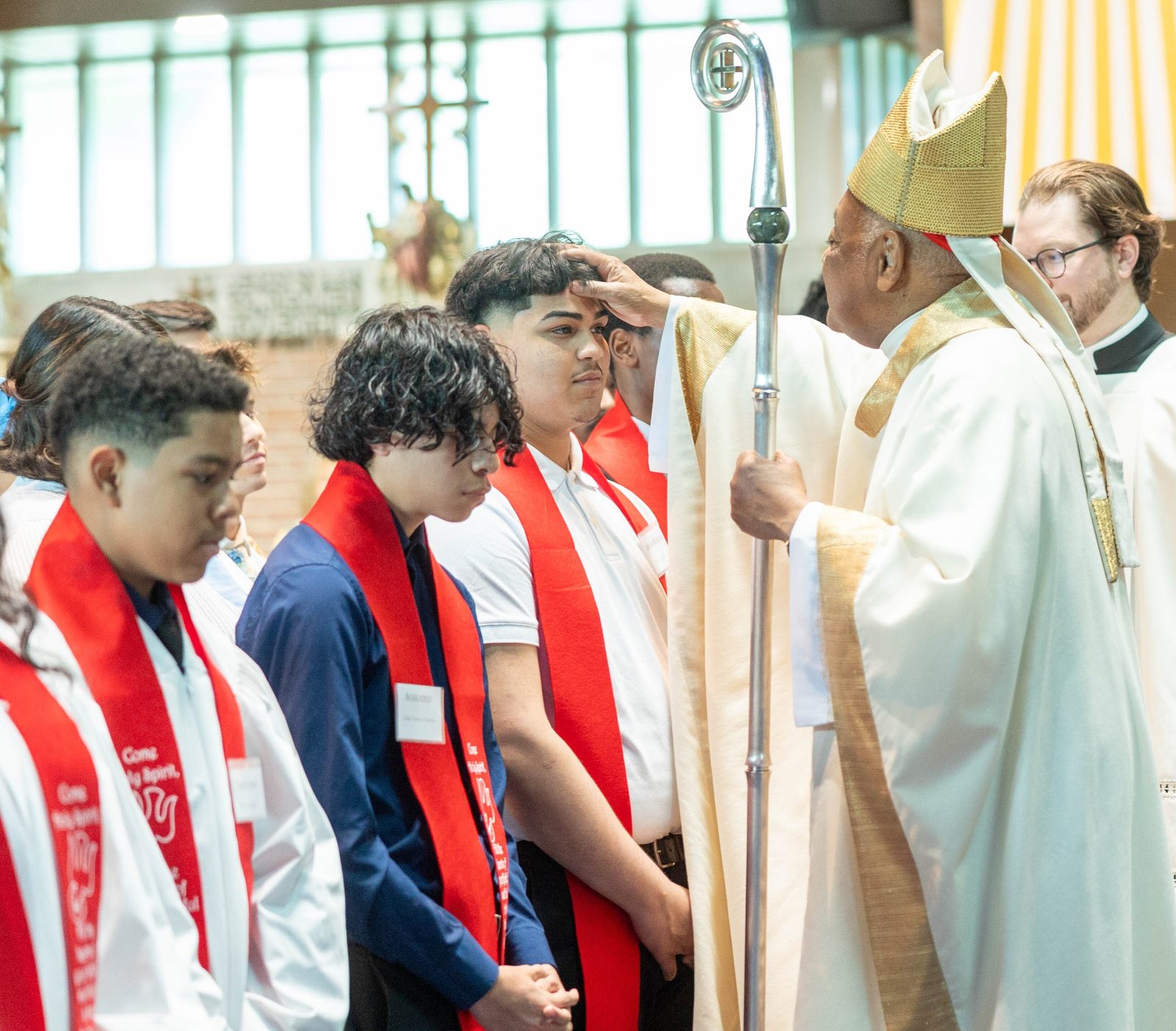 Grianny Cruz of the class of 2024 at Don Bosco Cristo Rey High School in Takoma Park receives the sacrament of Confirmation from Cardinal Wilton Gregory during a May 24 Mass at Our Lady of Sorrows Church. (Catholic Standard photo by Mihoko Owada)