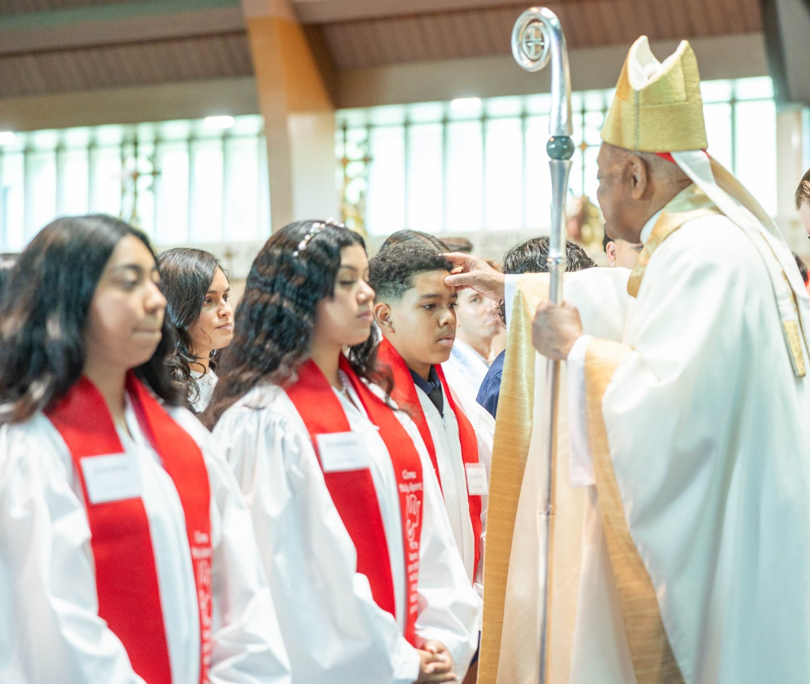 Elvis Orellana, a ninth grader at Don Bosco Cristo Rey High School in Takoma Park, receives the sacrament of Confirmation from Cardinal Wilton Gregory at a May 24 Mass at Our Lady of Sorrows Church. (Catholic Standard photo by Mihoko Owada)