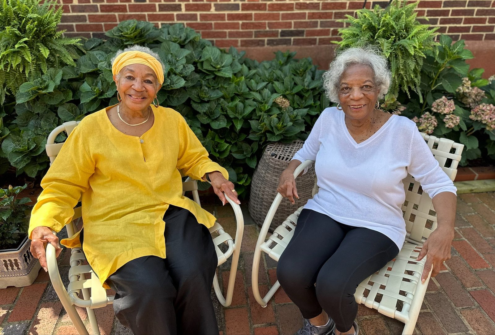 Sondra Dodson Raspberry and Joan Dodson Tillery sit outside Dodson Raspberry's garden. The two sisters remain close, as they live near one another, frequently go out together, and both are members of Immaculate Conception Parish in Washington, D.C. In an interview with the Catholic Standard newspaper, the sisters reflected on their experiences attending the March on Washington 60 years earlier on Aug. 28, 1963. The Catholic Standard’s articles highlighting people’s remembrances of the first March on Washington received an honorable mention for best reporting on senior citizens in the 2024 Catholic Media Awards competition of the Catholic Media Association. (Catholic Standard photo by Catherine Buckler)