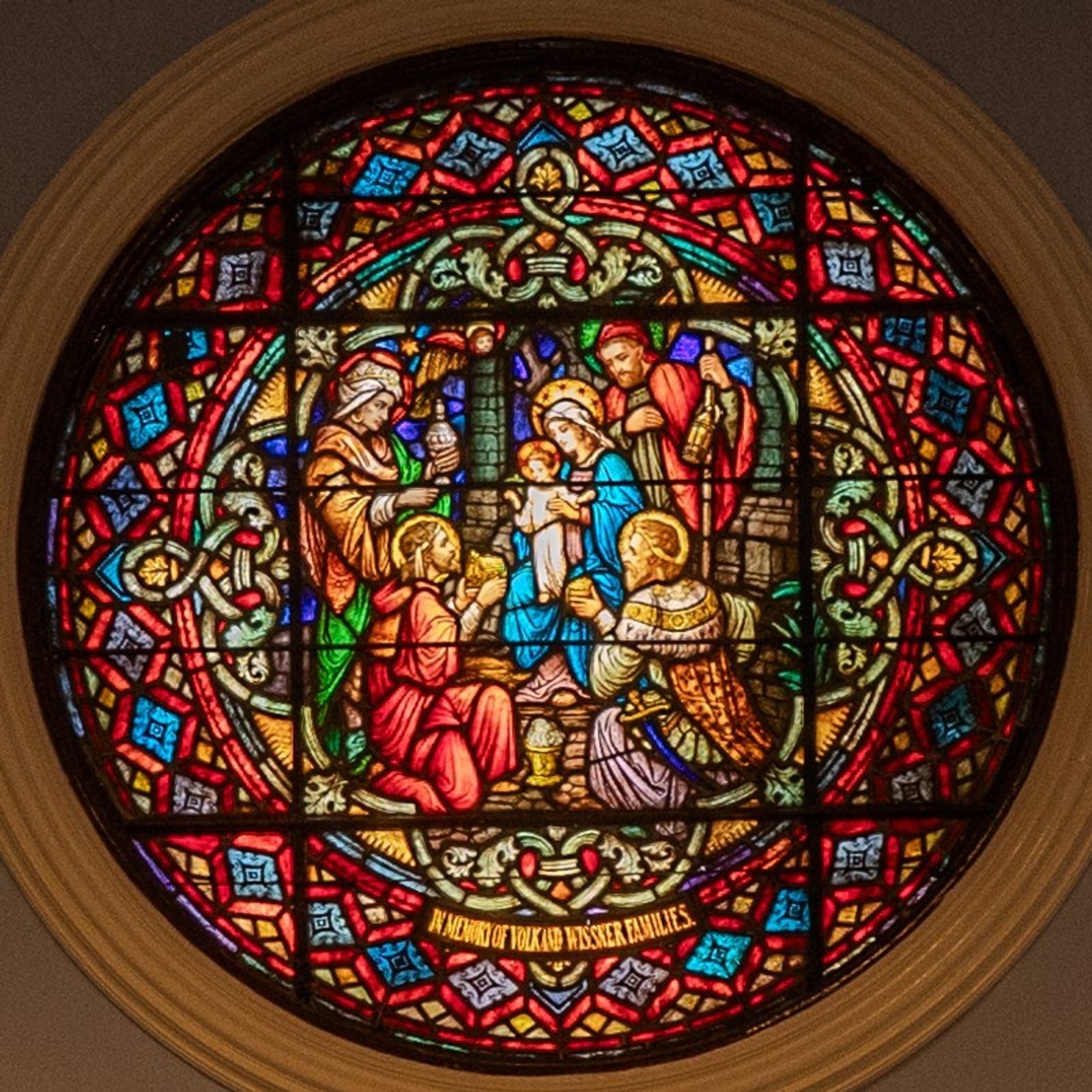 A stained glass window depicting the Epiphany scene of the three magi presenting gifts to the newborn Jesus is on the wall behind the altar at Epiphany Catholic Church in Washington, D.C., which is celebrating its 100th anniversary in 2025. (Catholic Standard photo by Mihoko Owada)