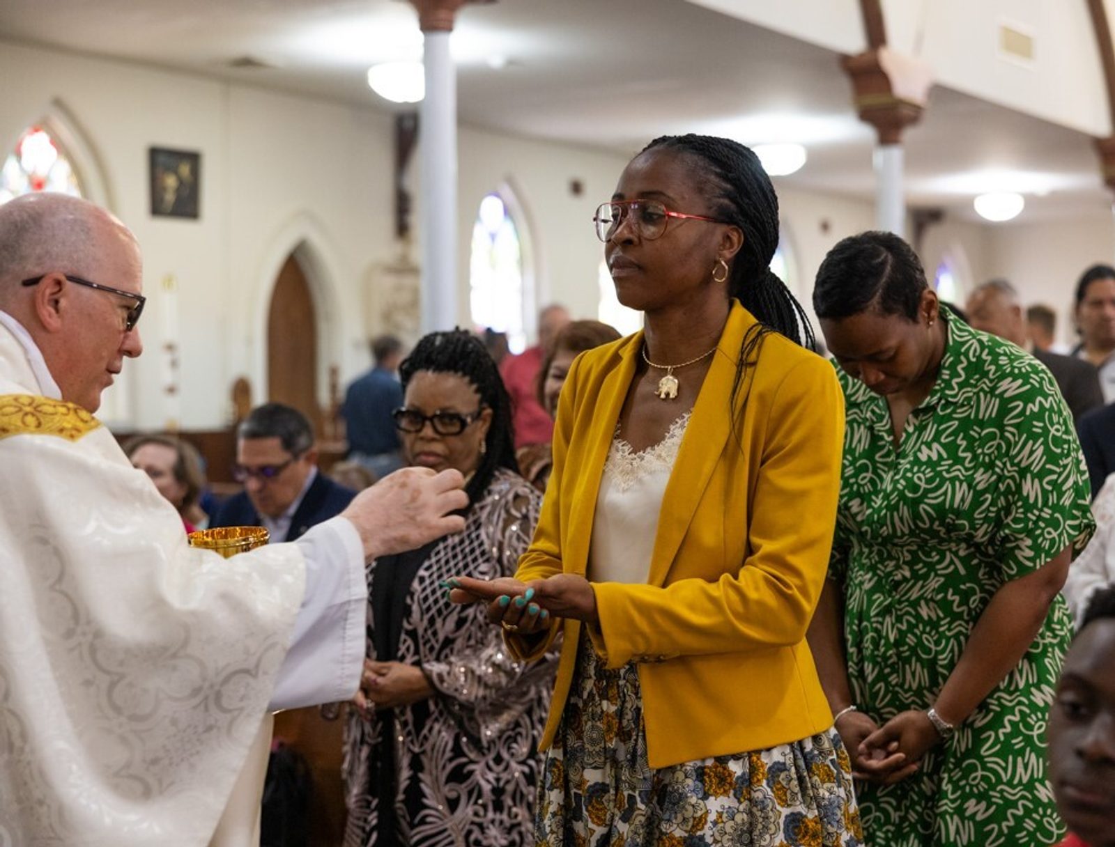 Father Thomas LaHood, the pastor of St. Mary of the Assumption Parish in Upper Marlboro, gives Communion to a woman during a Mass celebrating the parish’s 200th anniversary on June 2, 2024. (Catholic Standard photo by Andrew Biraj)