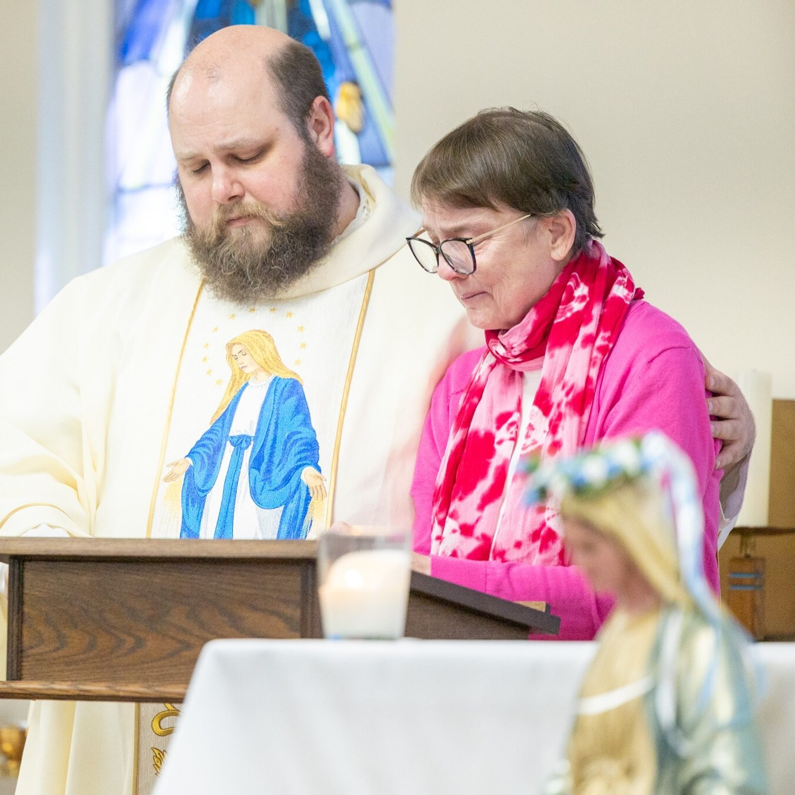 Father Patrick Mullan, the chaplain for the Office of Deaf and Disabilities Ministry of The Roman Catholic Archdiocese of Washington, joins Judy Barr as she paused while reading the intentions during a May 11 Mass at the Pope Francis Center in Landover Hills for people living with mental health challenges. (Catholic Standard photo by Mihoko Owada)